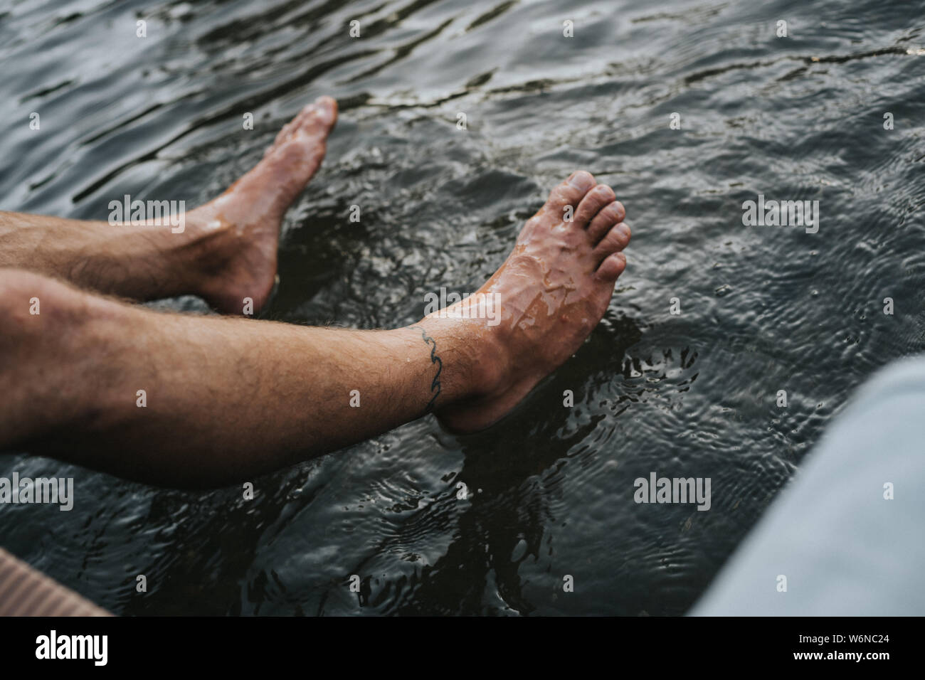 Tatuato piede umano nell'acqua di un fiume Foto Stock