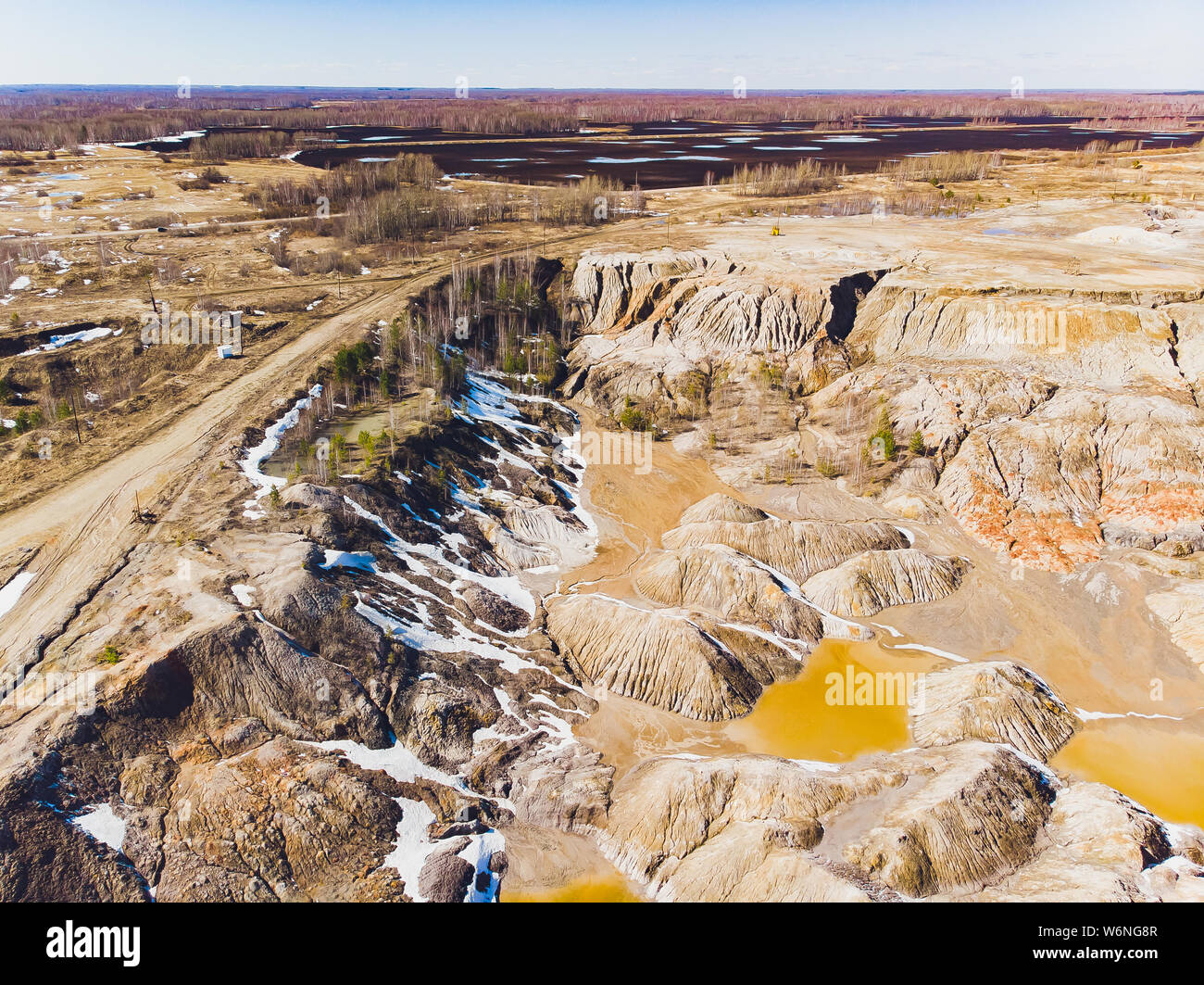 Argilla cava aperta Mars paesaggio con acqua di colore arancione. Abbandonato il Rock Texture porcellana vecchia miniera di buca di Ural. Erosione Crack Hill superficie desertica. Foto Stock