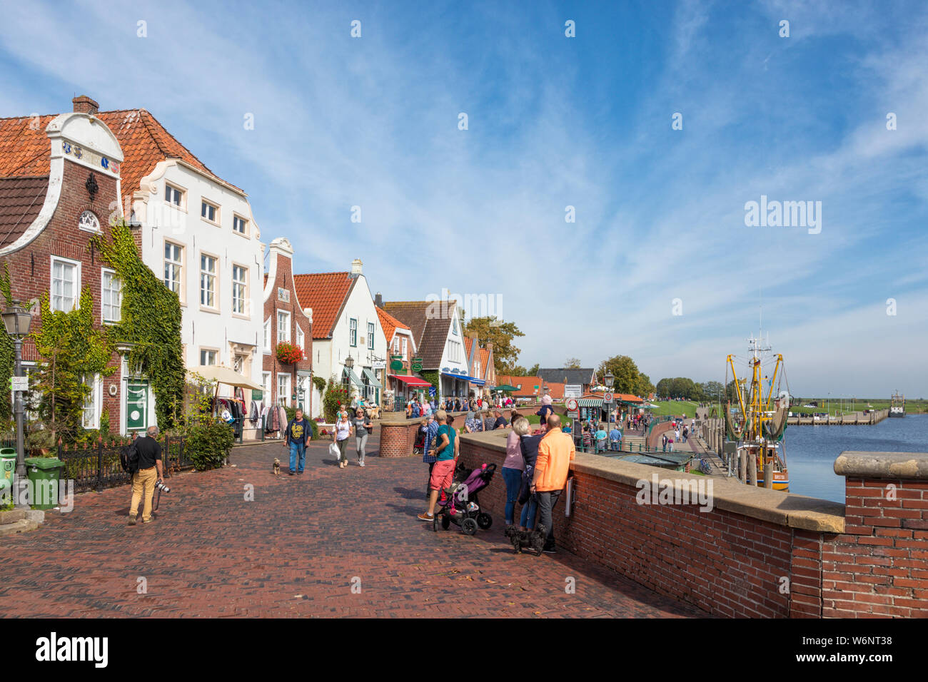 Villaggio di Greetsiel, Bassa Sassonia, Germania, i turisti passeggiano lungo il lungomare e il porto Foto Stock