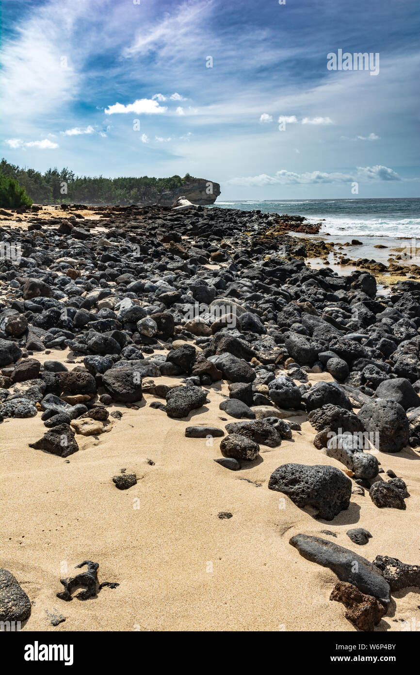 Rocce laviche sulla sabbia della spiaggia, Kauai, Hawaii Foto Stock
