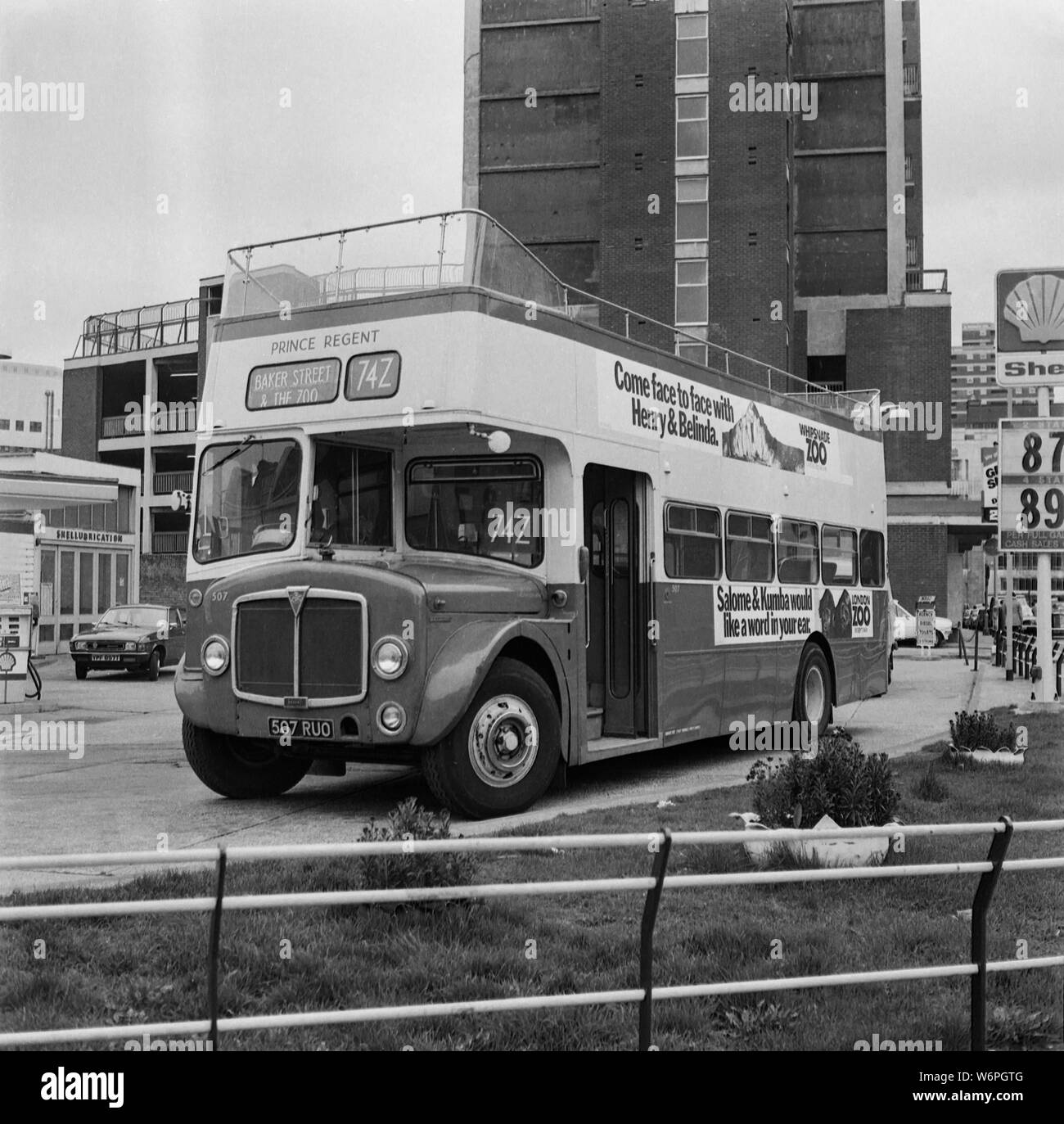 Una parte superiore aperta AEC Routemaster double decker autobus parcheggiato in un garage della Shell a Londra durante gli anni settanta Foto Stock