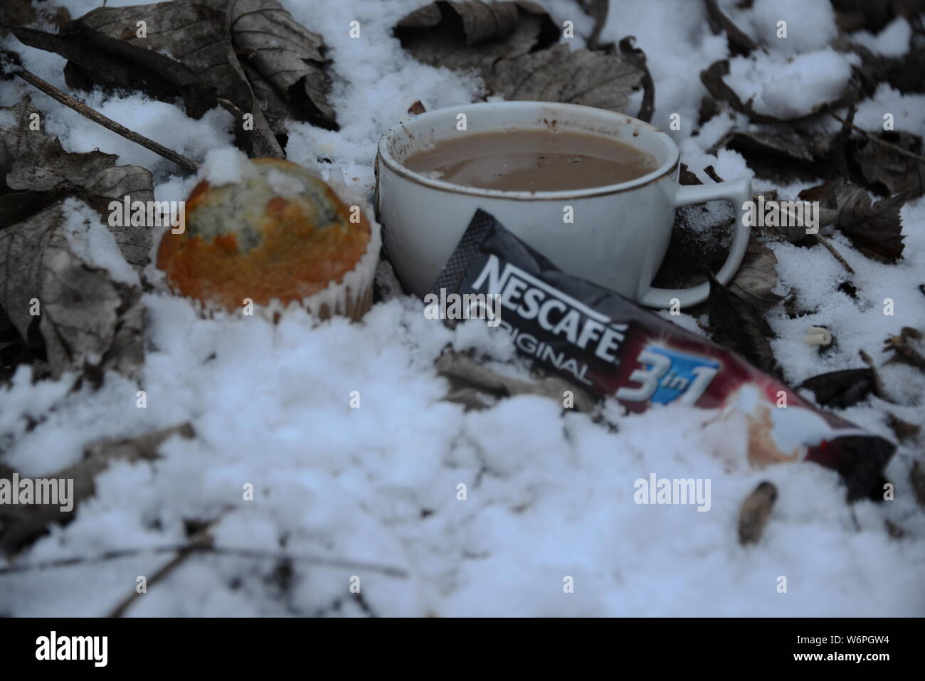 Tazza di Nescafe in inverno la refrigerazione con neve tazza di caffè e una fetta di torta tempo di interruzione in condizioni di clima freddo di bere il caffè esce intorno a Snowy White snow Nescafe Foto Stock