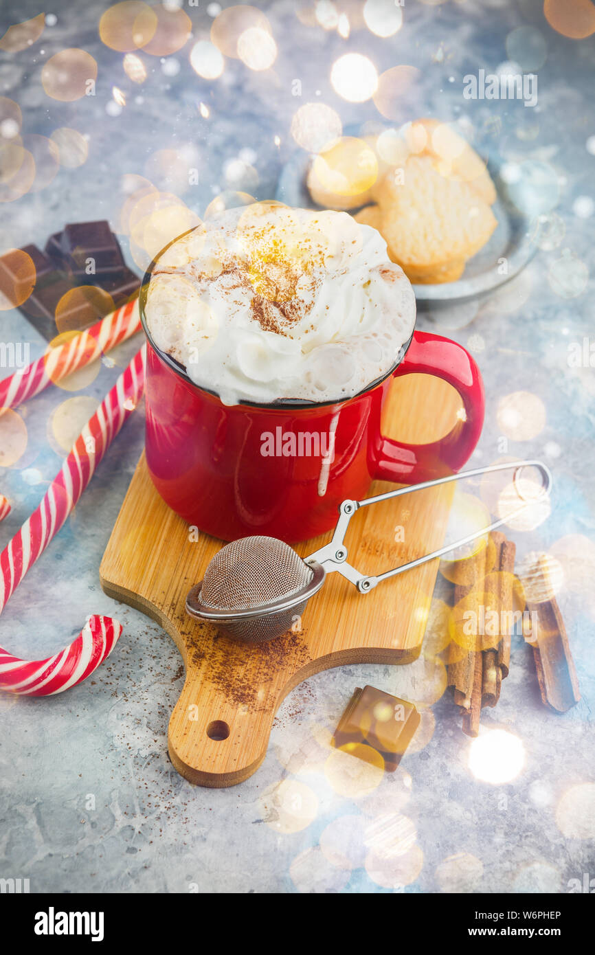 Natale smaltato rosso con tazza di cioccolata calda e panna montata, bastoncini di cannella, anice stelle e abbondante zucchero frollini cookies e candy canes su Foto Stock Natale smaltato rosso con tazza di cioccolata calda e panna montata, bastoncini di cannella, anice stelle e abbondante zucchero frollini cookies e candy canes su Foto Stock