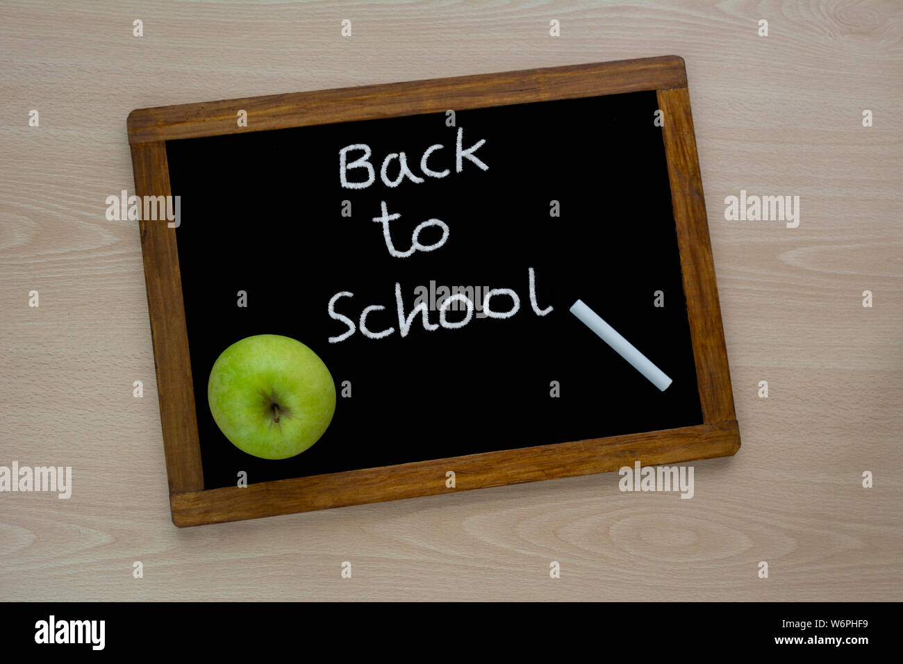 Si torna a scuola, l'iscrizione sul mini-board, il layout della scheda e il gesso sulla scrivania , con mela verde. Il concetto di preparazione per sc Foto Stock