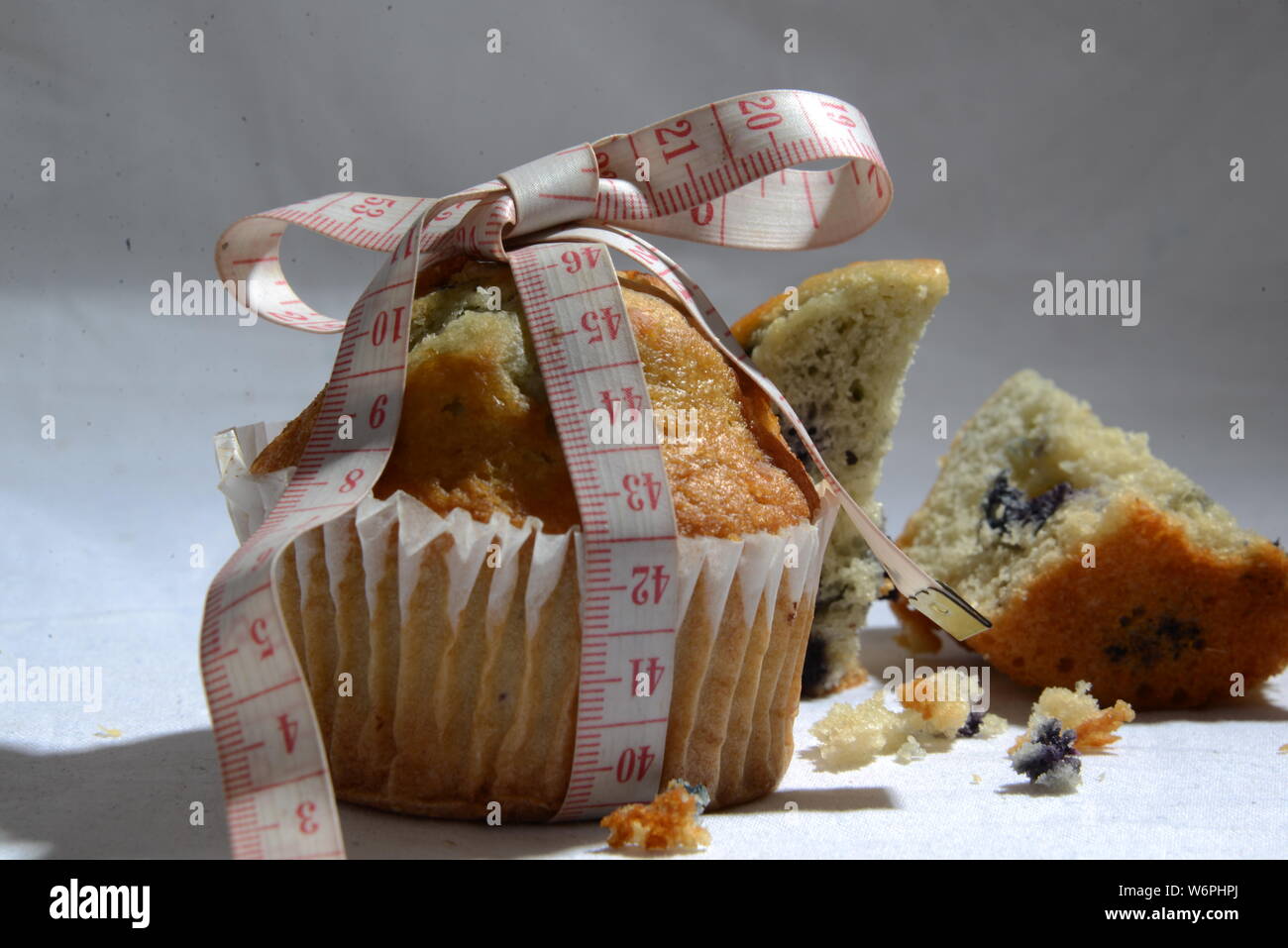 Cup cake e torte e perdere peso biscotto sta grasso e simbolo di dimensionamento del misuratore di peso la torta dal vicino foto significative junk food Foto Stock