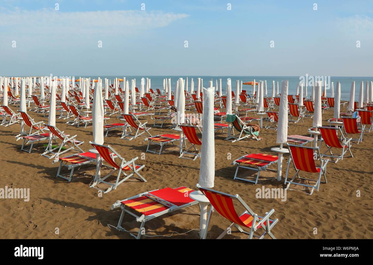 Molti ombrelloni e sdraio sulla spiaggia sabbiosa del resort in estate Foto Stock