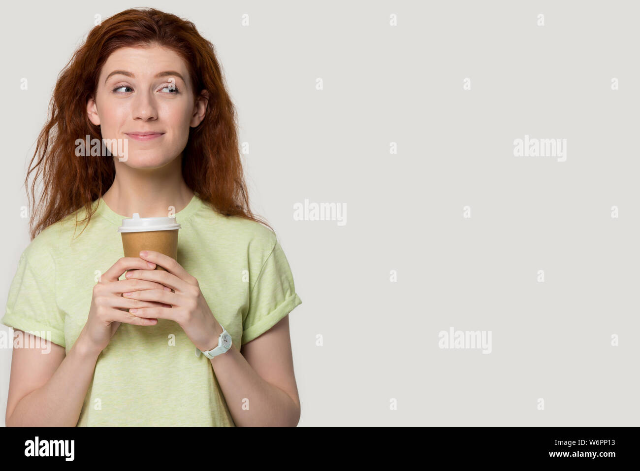 Cutie ragazza rappresentano oltre il grigio di sfondo per studio azienda tazza da caffè Foto Stock