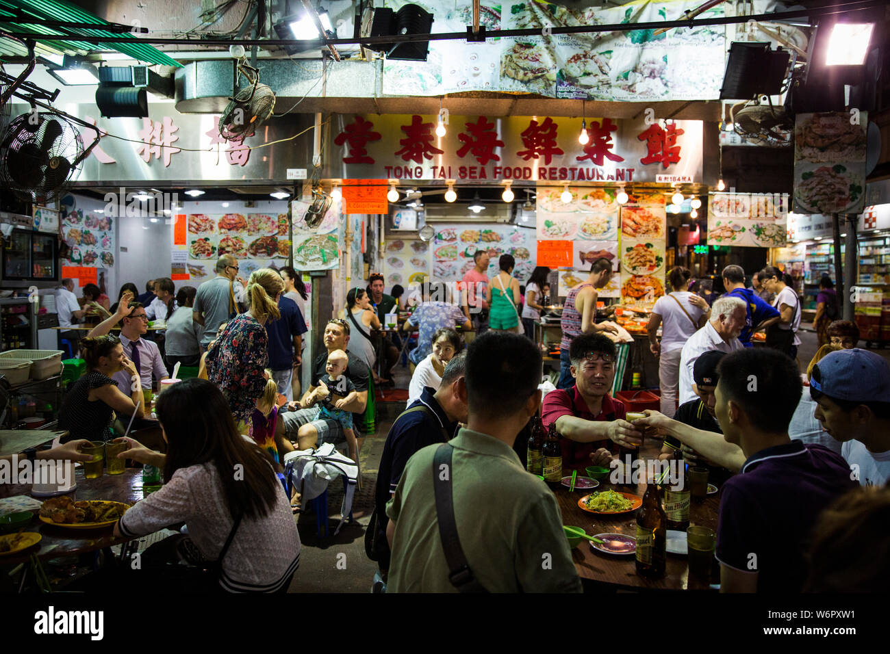 Persone di mangiare in un Kowloon dai pai dong. Hong Kong Foto Stock