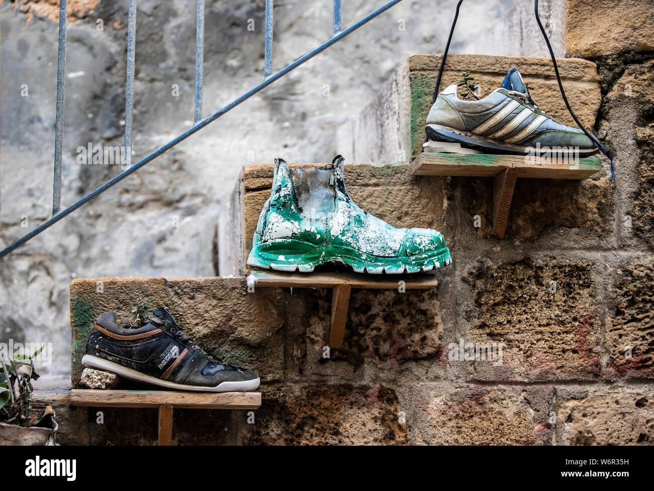 Tre vecchie scarpe fissato su una scala Foto Stock