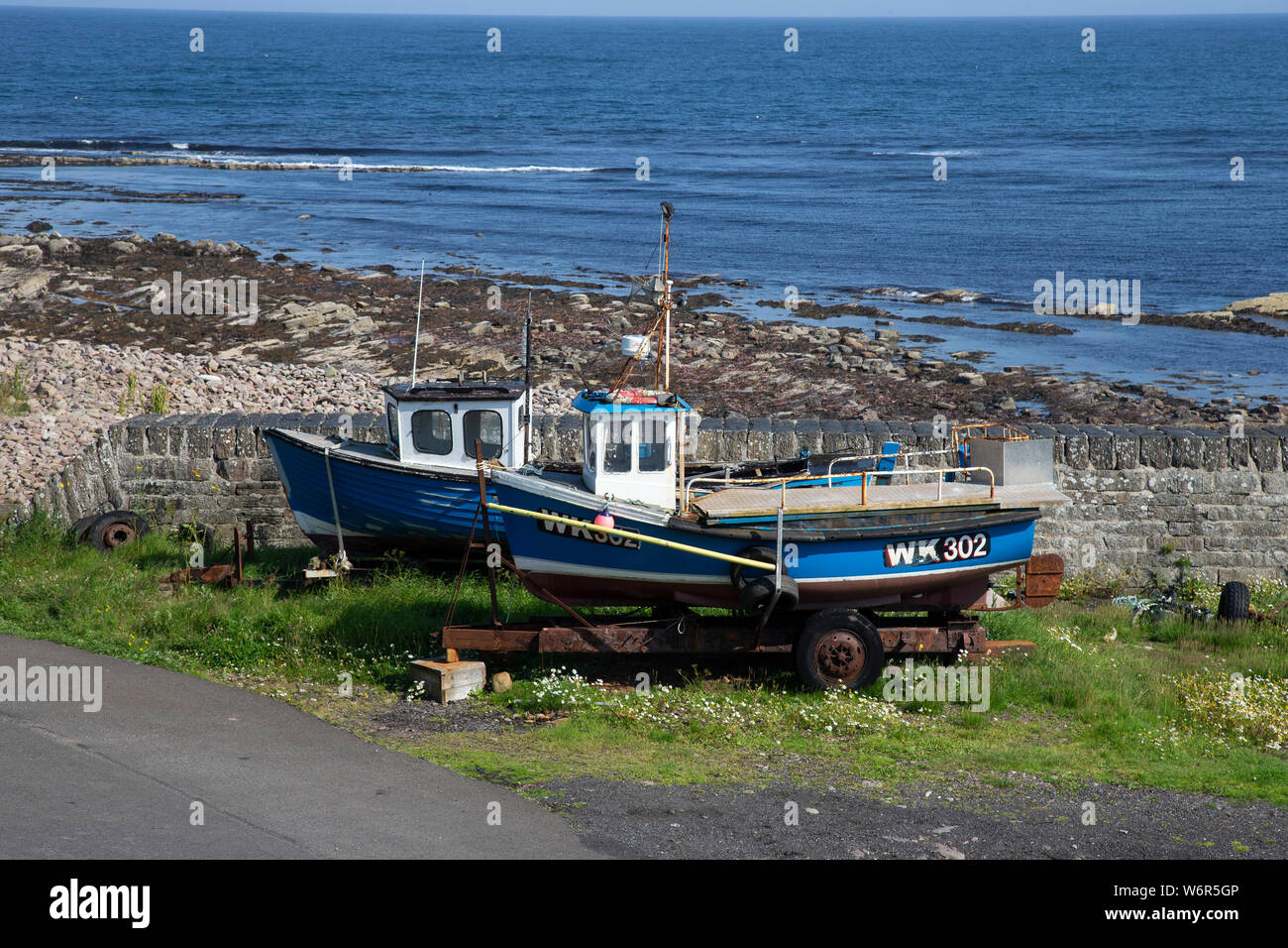 Due abbandonato barche da pesca nel porto di Keiss, Caithness compresi WK302 che è stato salvato dallo stoppino scialuppa di salvataggio nel maggio 2014 durante il riempimento con acqua Foto Stock