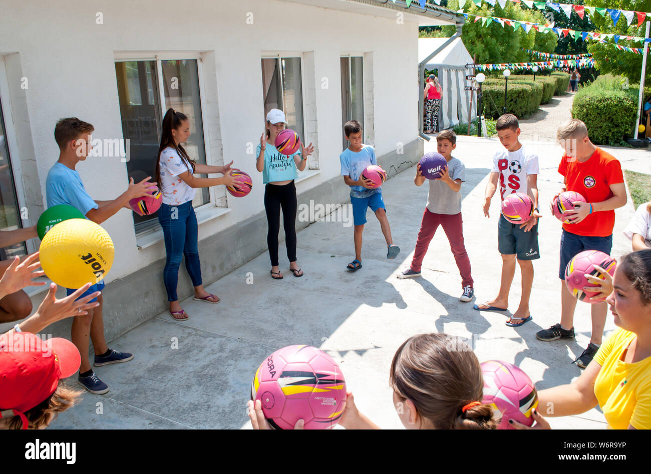 Odesa rgn. Ucraina, 6 Agosto 2018: Ragazzi, contemporaneamente tirando la palla in un cerchio in un gioco di sport, team building Foto Stock