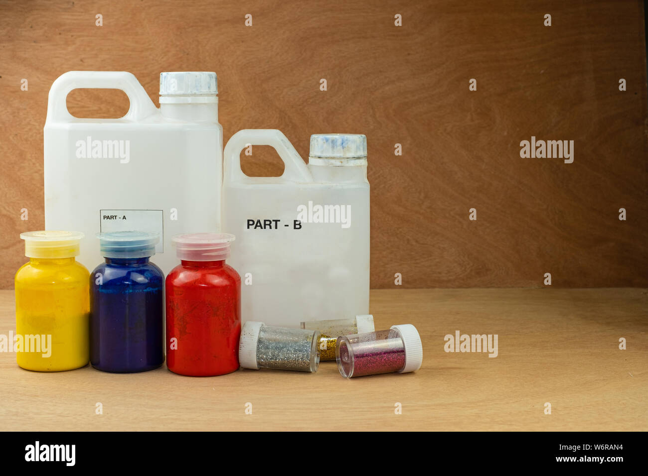 La miscelazione di colore della resina epossidica in una tazza di plastica per la colata di stabilizzazione e legno di pino ibrido a cono Foto Stock