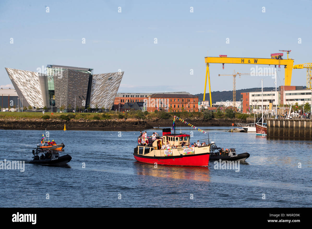 Flottiglie di navi portando bandiere arcobaleno in Belfast come essi sail dalla bocca di porto di Belfast fino al fiume Lagan, prima di una presentazione a Belfast Lord Mayor John Finucane con la prima bandiera di orgoglio che volerà dal Municipio, precedendo il Belfast Pride Parade di sabato. Foto Stock