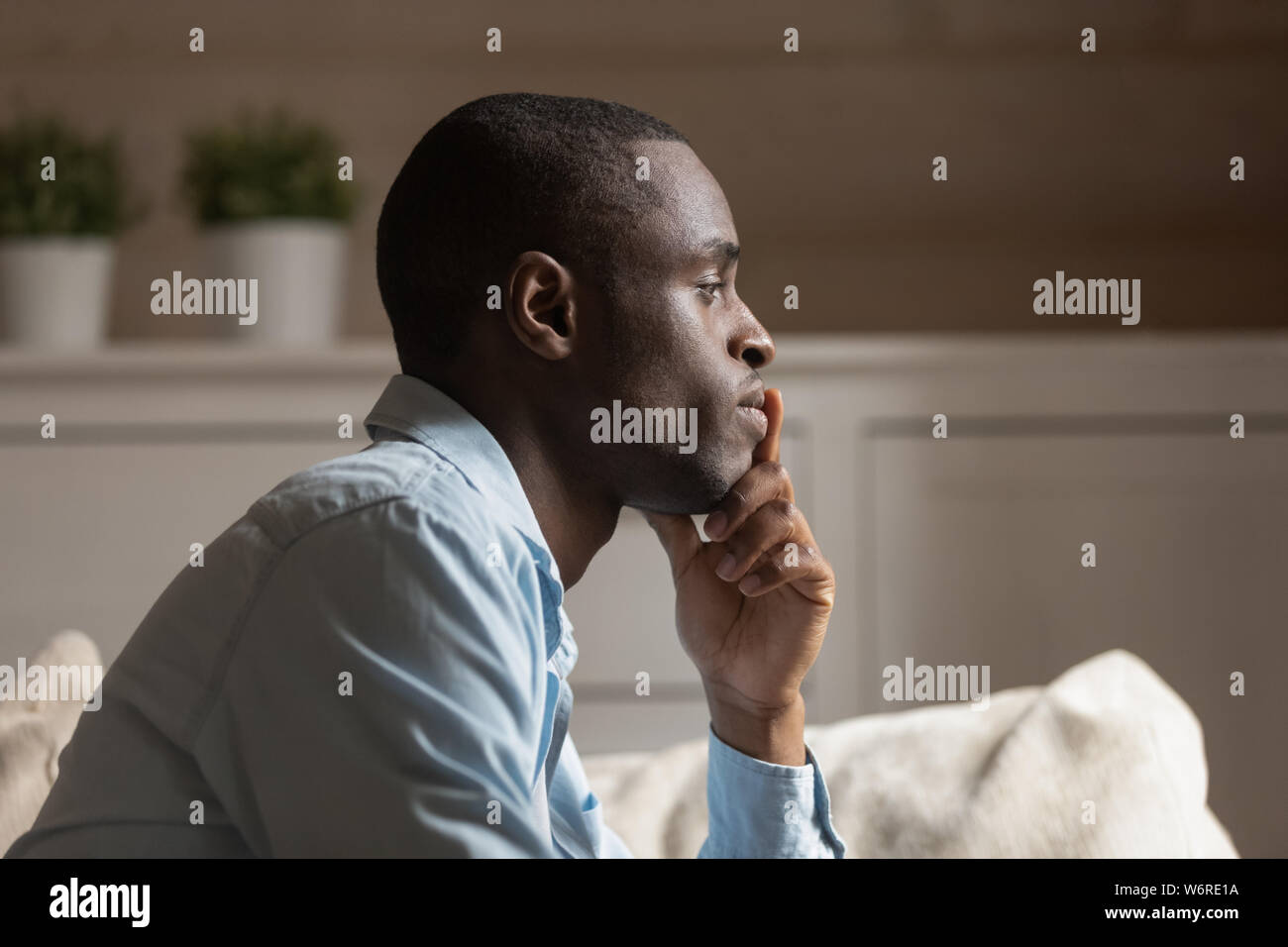 Il profilo della faccia triste ragazzo africano pensando al chiuso Foto Stock