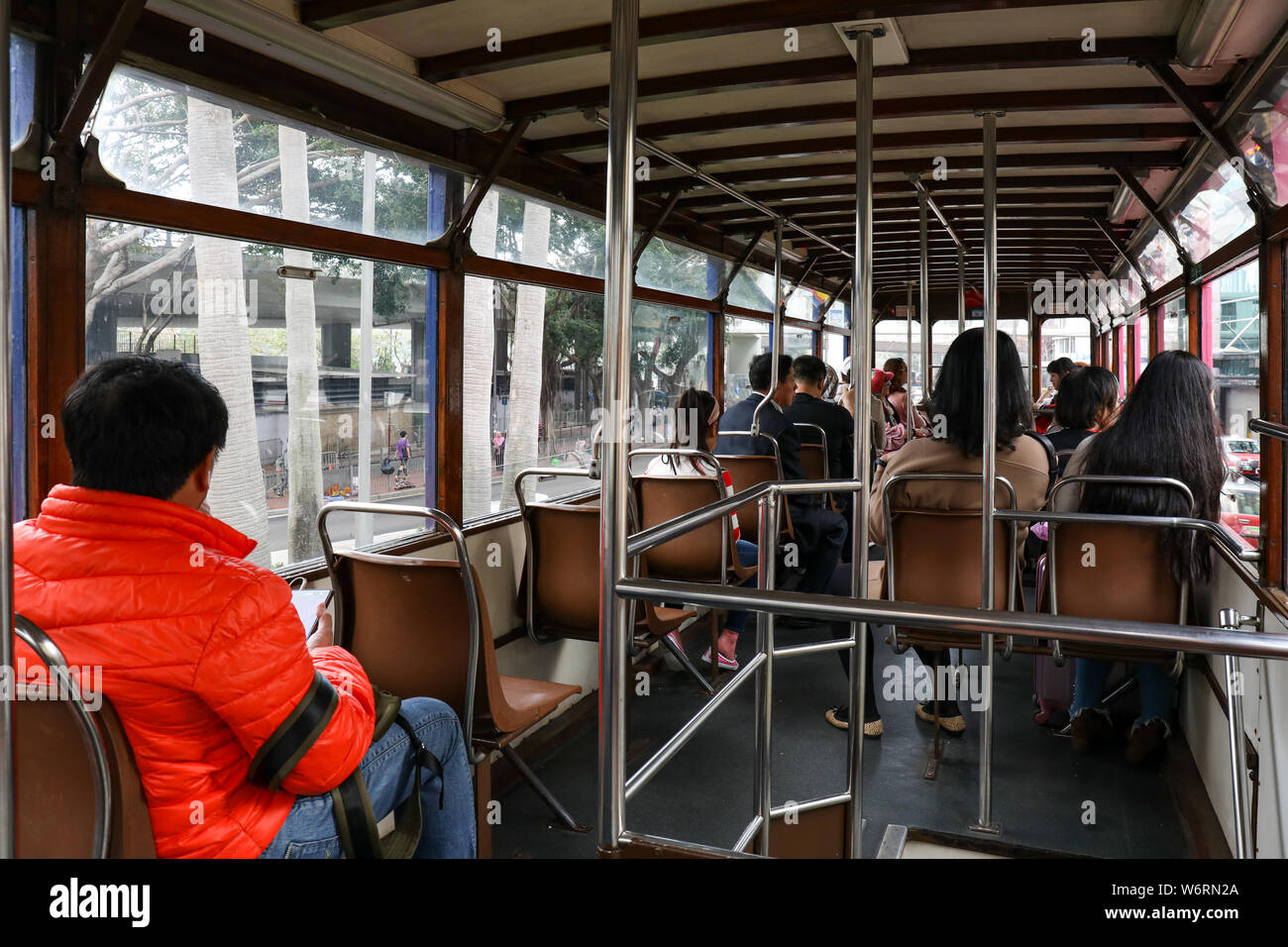I passeggeri sul pianale superiore di double-decker tram in Hong Kong Foto Stock