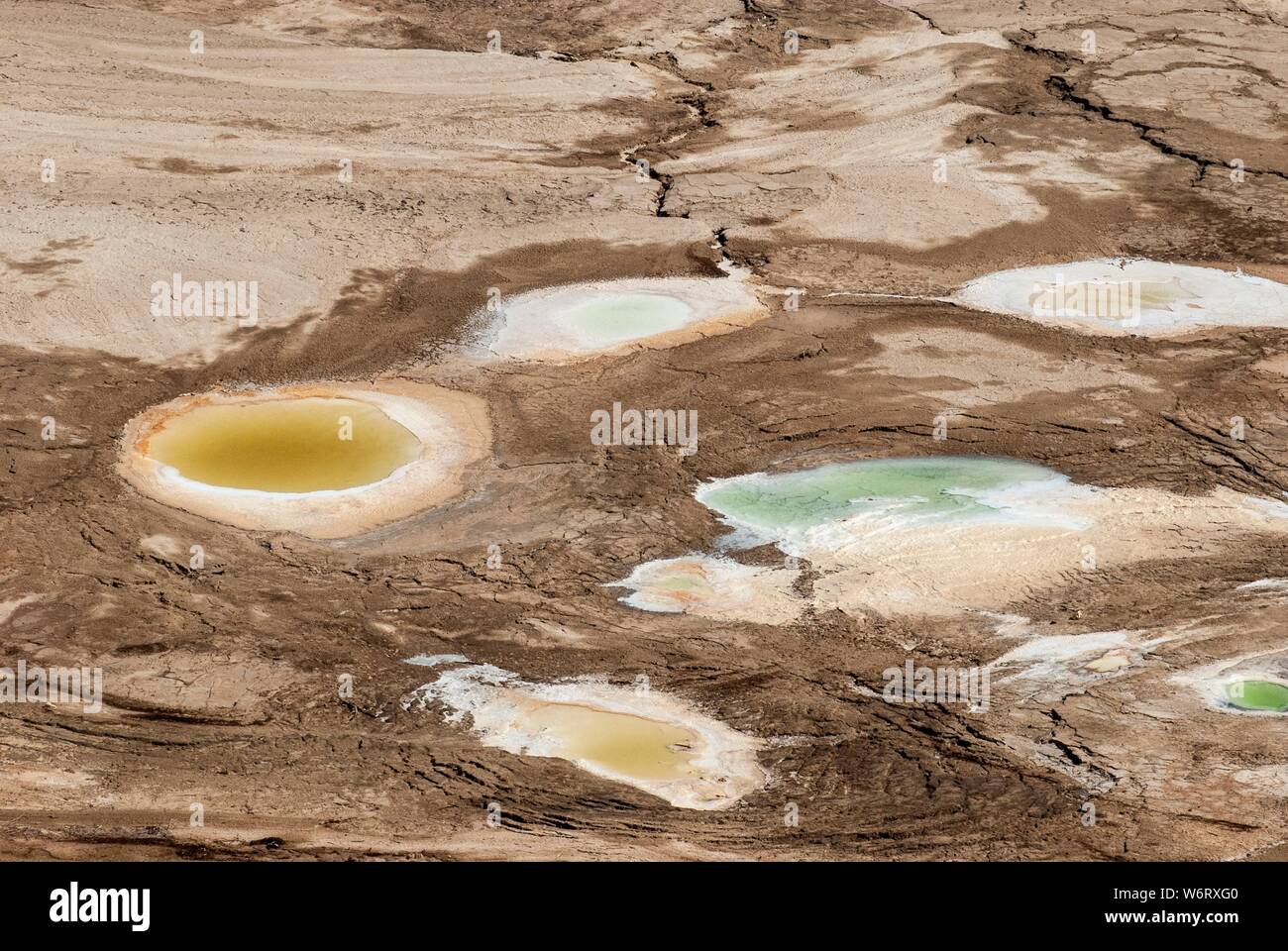 Dolina causato dalla recessione a livello acqua del Mar Morto, Israele. Un acqua calda primavera riempie il foro. Foto Stock