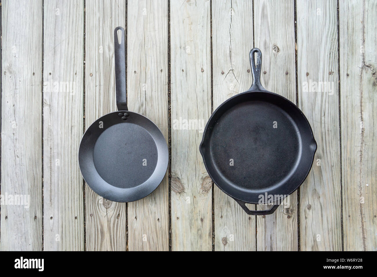 Tradizionale ghisa vs acciaio al carbonio versus teflon opzioni di cottura - vuota stanza vuota per il testo o per copiare lo spazio. Due pentole pezzi - fornello da cucina per Foto Stock