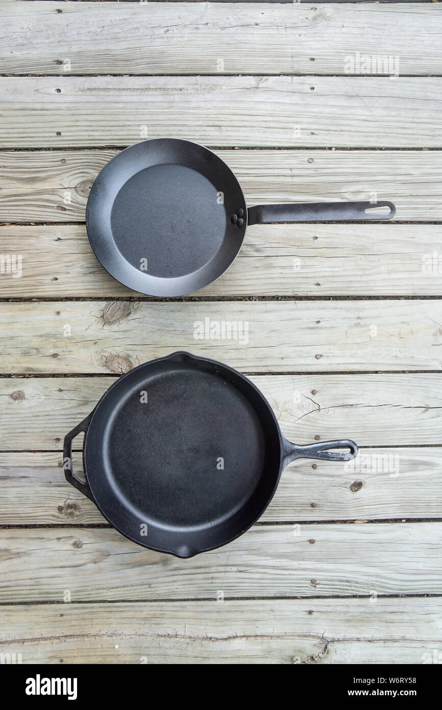 Tradizionale ghisa vs acciaio al carbonio versus teflon opzioni di cottura - vuota stanza vuota per il testo o per copiare lo spazio. Due pentole pezzi - fornello da cucina per Foto Stock