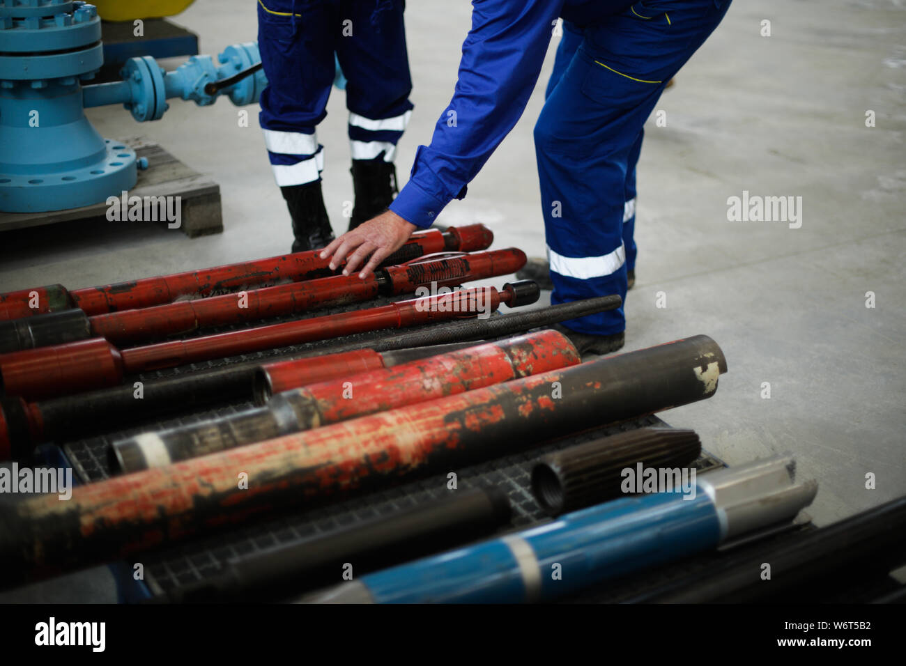 Dettagli con le mani di un lavoratore toccando vecchie e arrugginite di ferro pesante attrezzatura di perforazione utilizzati nell'industria petrolifera e del gas Foto Stock