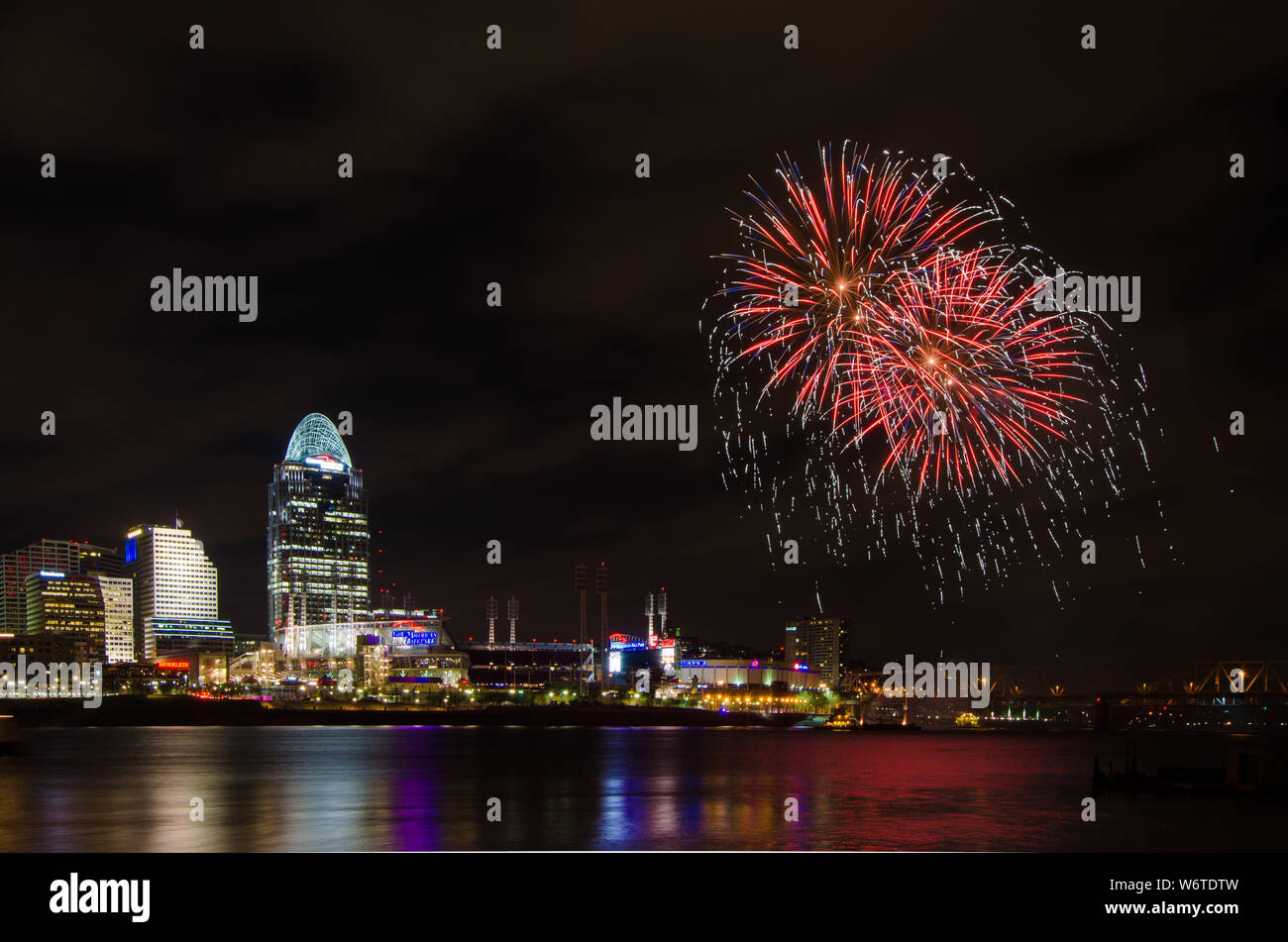 Il lancio di fuochi d'artificio da una chiatta nel fiume Ohio a Cincinnati, Ohio, Stati Uniti d'America, contro Cincinnati cityscape, compresi Great American Ball Park. Foto Stock