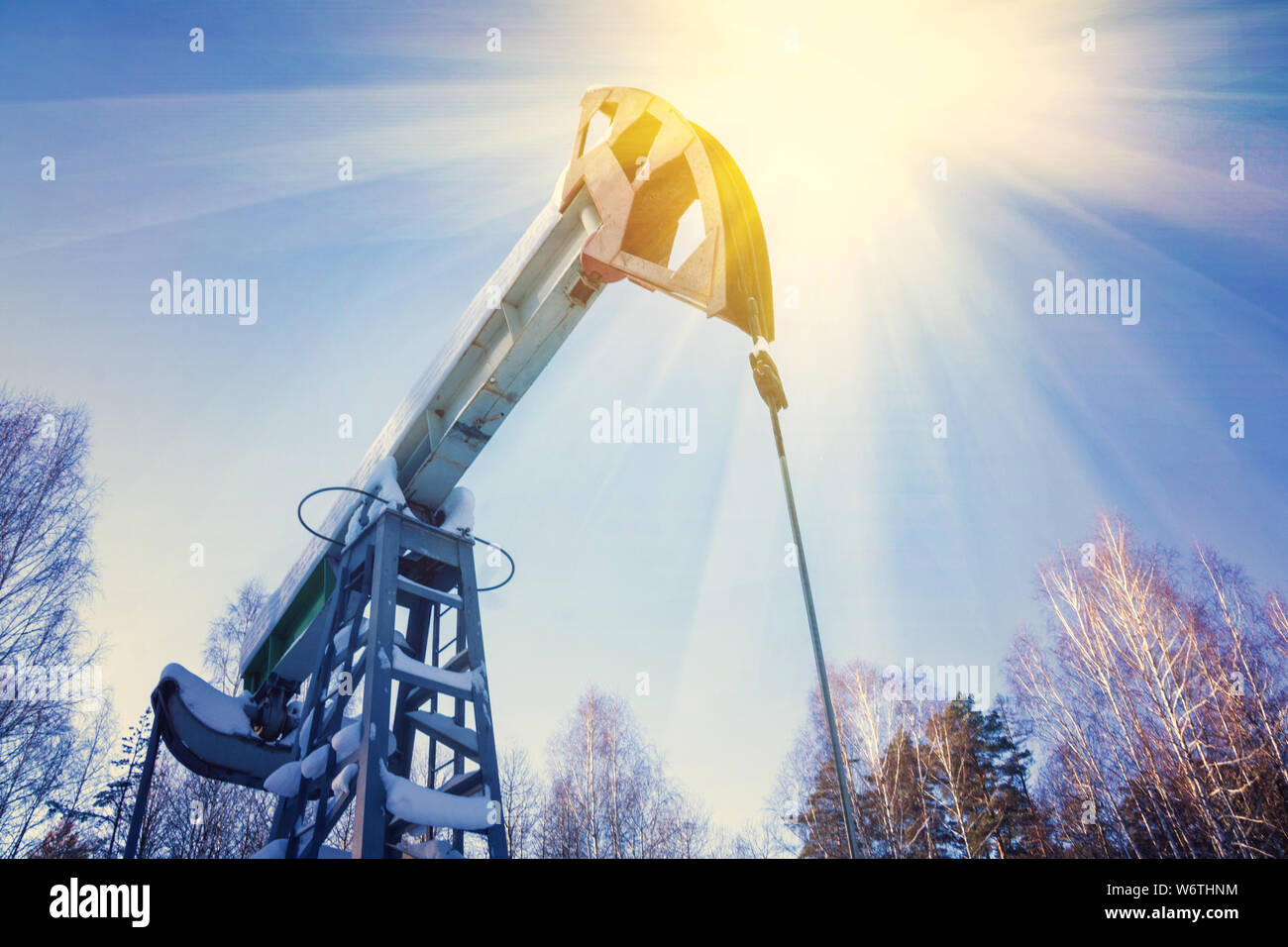 Campo di olio con pompa a jack, profilato sul cielo blu con nuvole bianche, in una giornata di sole in primavera Foto Stock