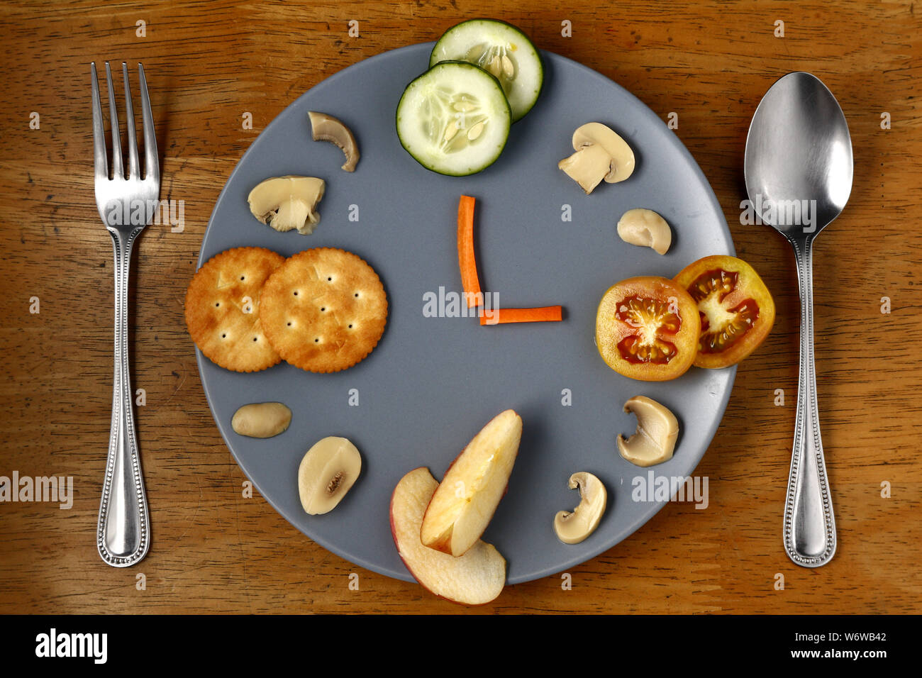 Foto di diversi alimenti sani disposti come un orologio su una piastra. Foto Stock