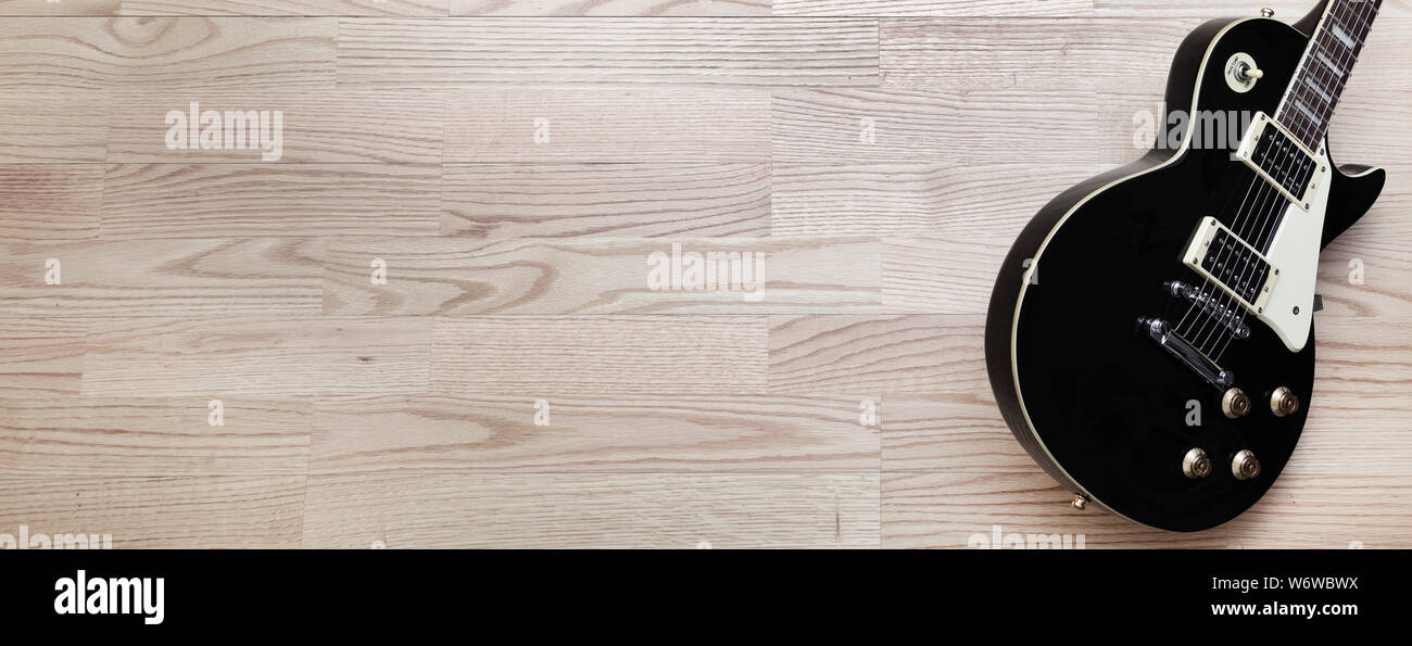 Un retrò chitarra elettrica immagine banner su uno sfondo di legno con spazio di copia Foto Stock