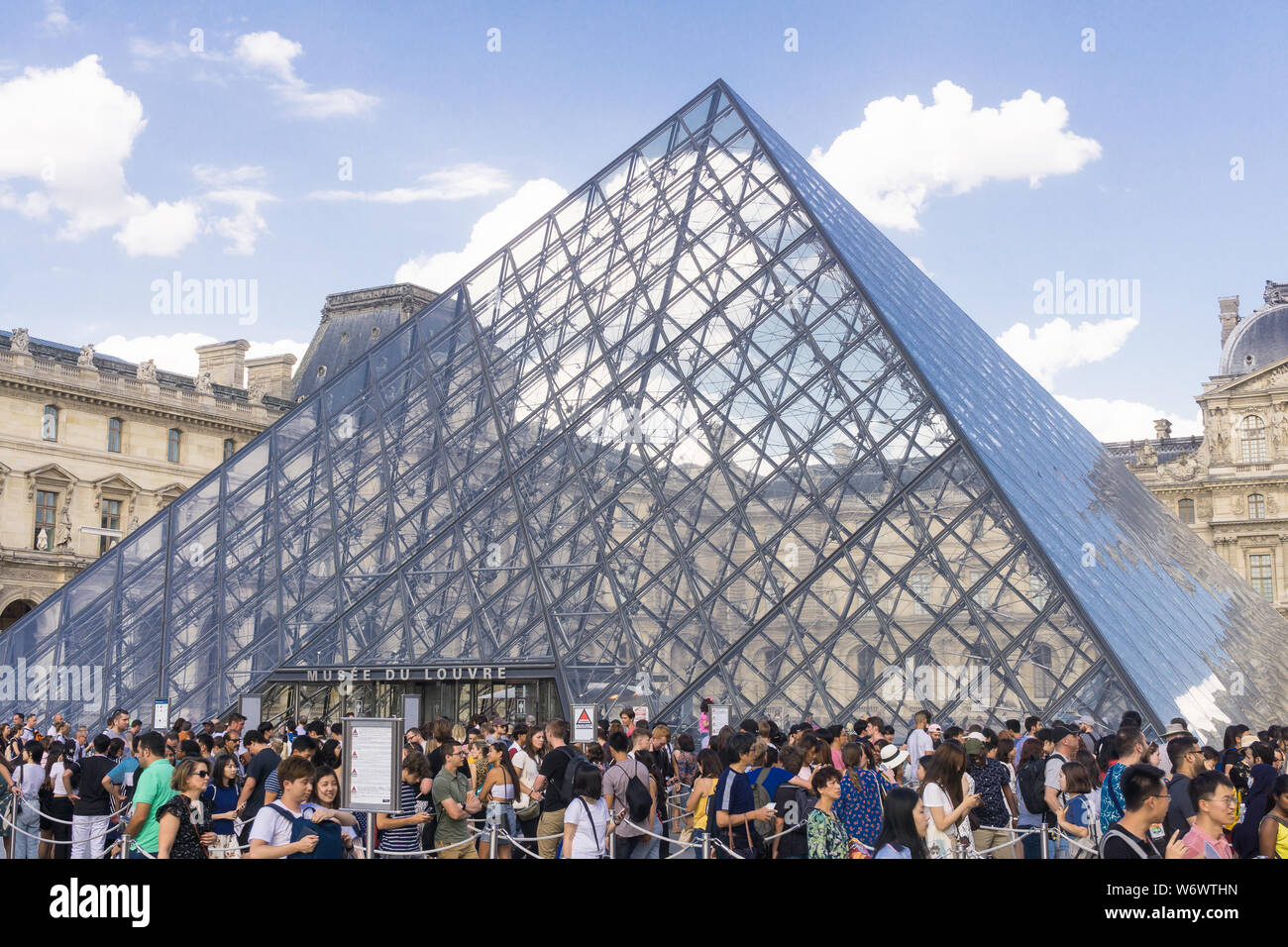 Louvre Parigi overtourism - folla di turisti in coda per accedere al museo del Louvre su un tardo pomeriggio a Parigi, in Francia, in Europa. Foto Stock