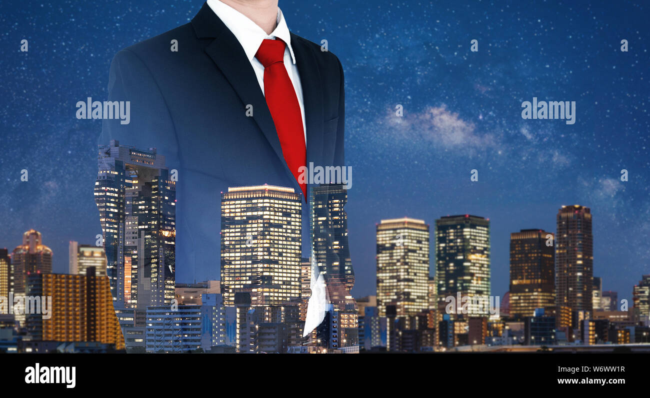 Imprenditore in abito nero e cravatta rossa, con doppia esposizione della città di notte Foto Stock