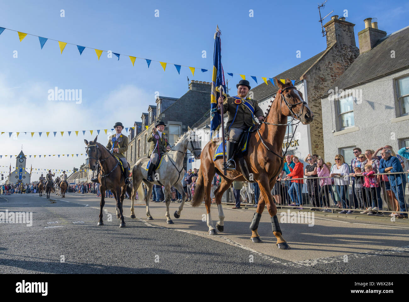 Scozia , Lauder , Scottish Borders , Berwickshire , UK, Regno Unito. 3 agosto 2019 Lauder Equitazione comune 2019. Il clou della Lauder comune settimana di equitazione, Lauder 'Cornet' Christopher Purves è incaricato di condurre una parata di 400 circa cento cavalli in un giro della città di frontiera confini, che porta la città bandiera e colori lungo il tragitto. Pic Phil Wilkinson / Alamy Live News Foto Stock