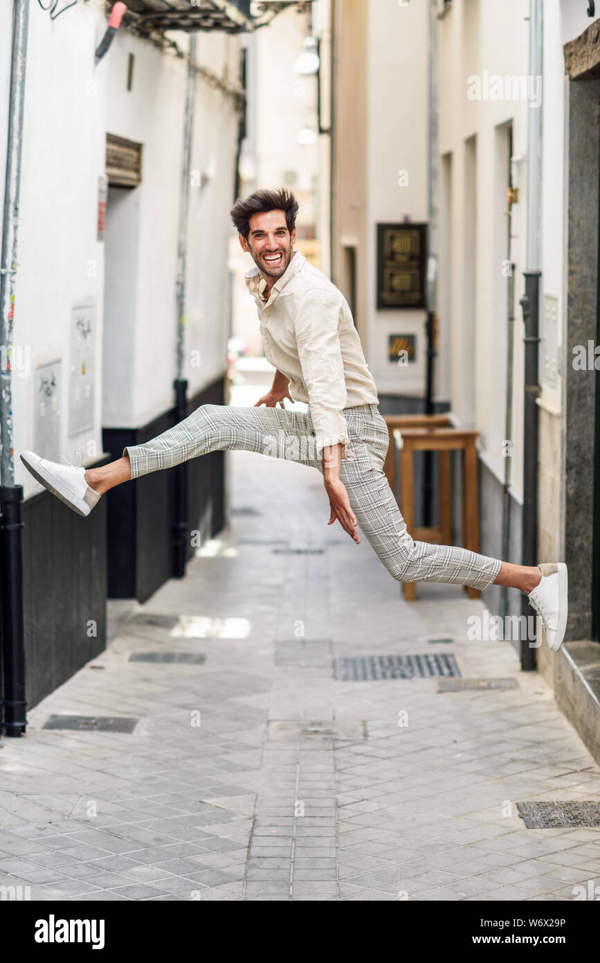 Giovane uomo felice saltando in strada. Foto Stock