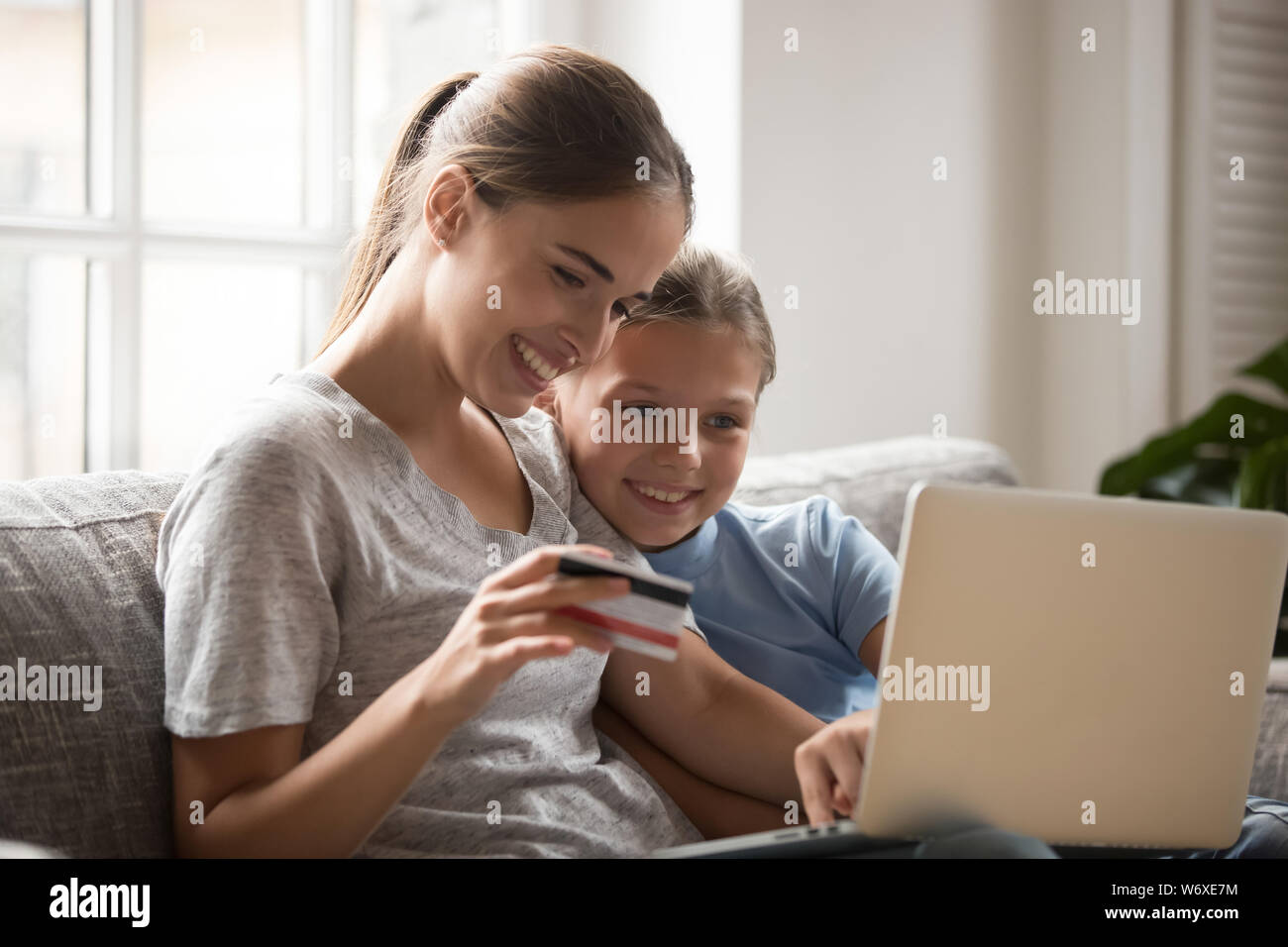 Madre e figlia con la carta pagare denaro e acquisto online Foto Stock