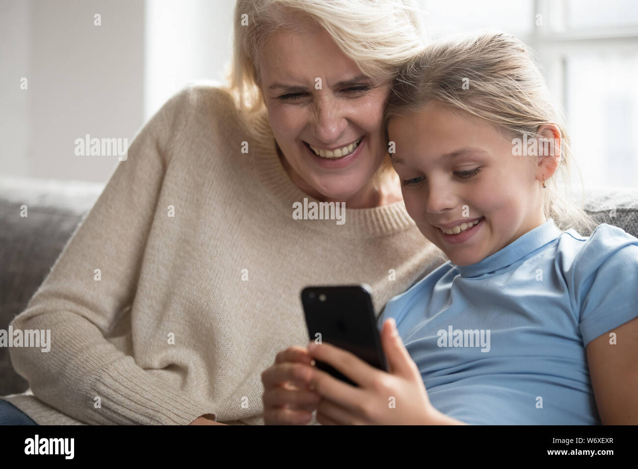 Nonna e nipote al divertimento in Internet utilizzando lo smartphone Foto Stock