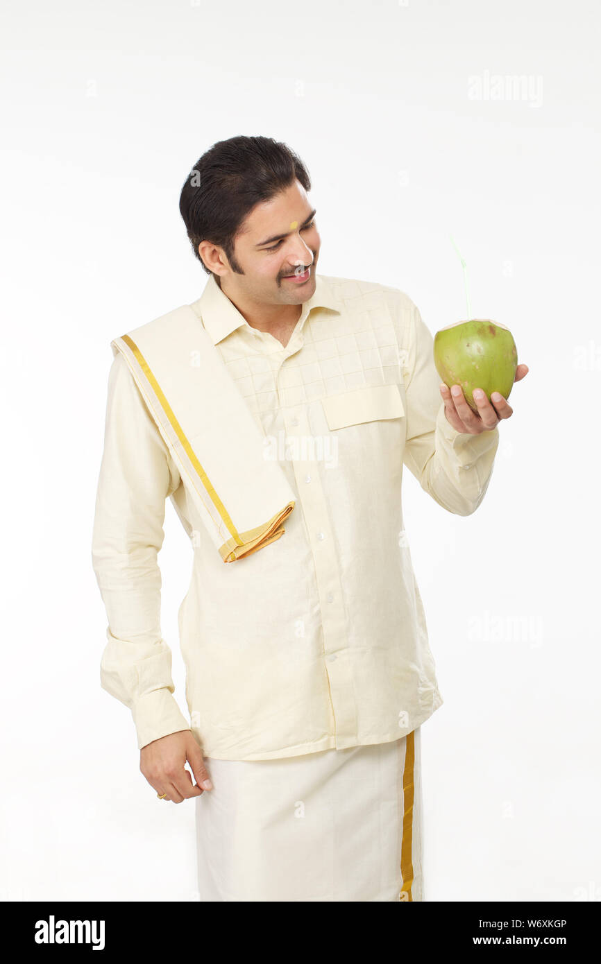 Uomo indiano del sud che tiene l'acqua di cocco Foto Stock