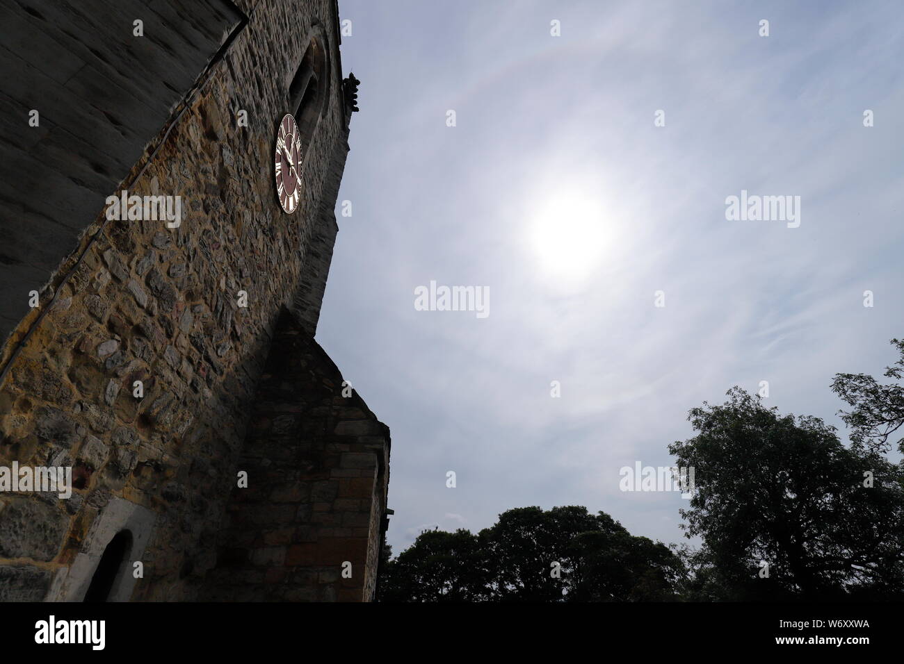 Chiesa di Santa Maria dell'Inghilterra in Kippax, Leeds con un alone di sole nel cielo Foto Stock