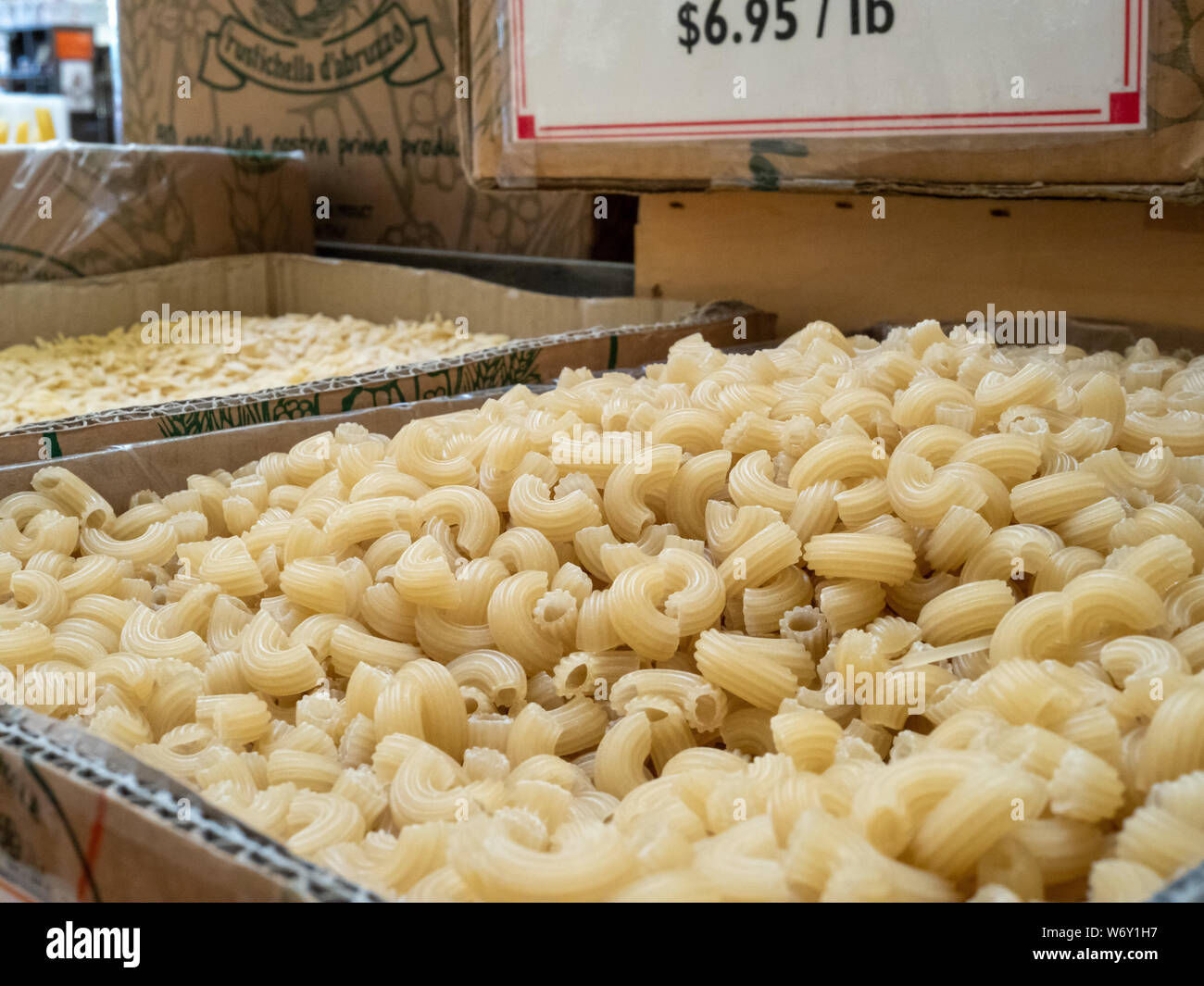 Pila di essiccato maccheroni nella casella per la vendita con segno Foto Stock