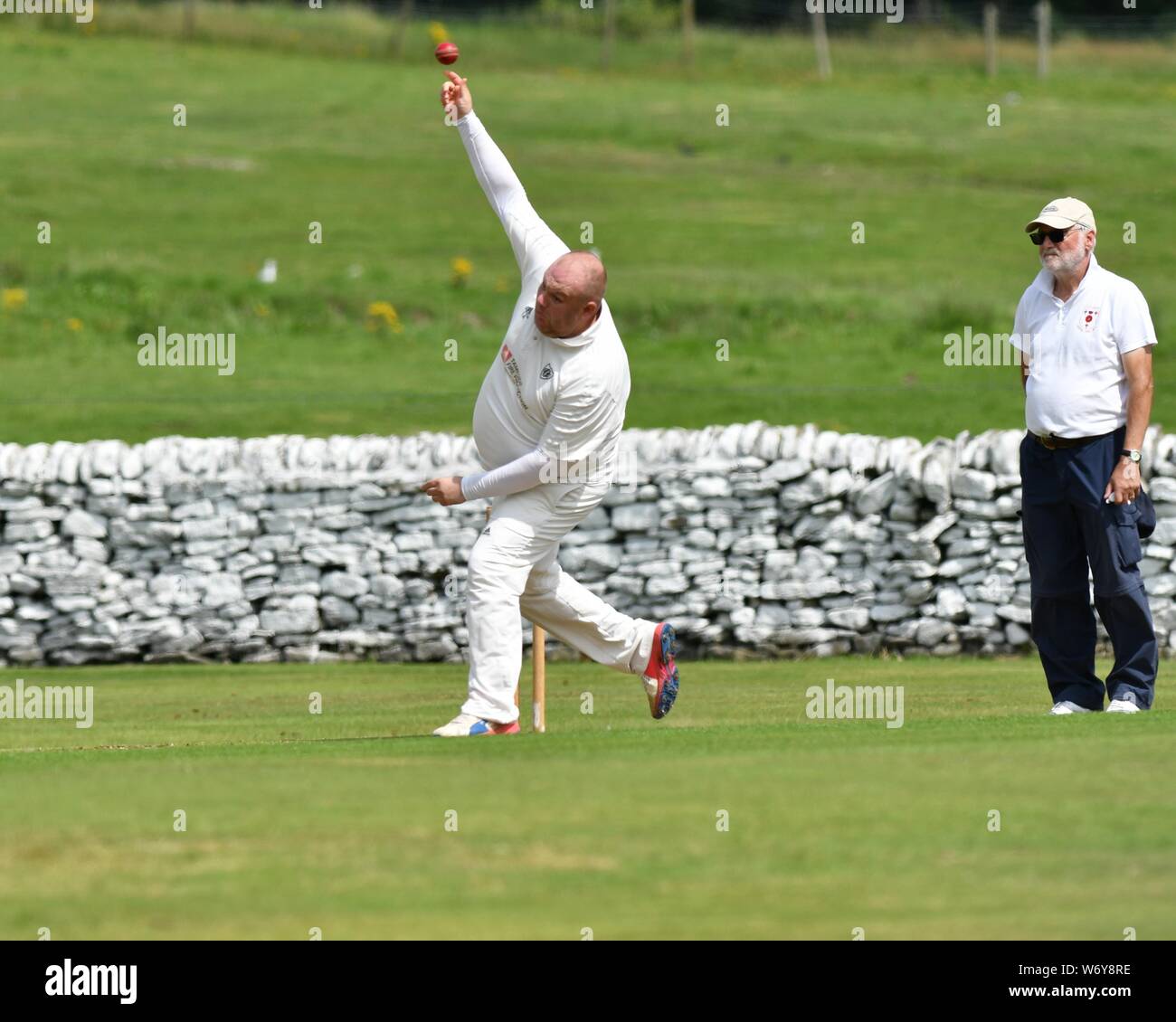 Un bowler lenta in azione nella partita tra vecchi Glossop e Tintwistle Foto Stock