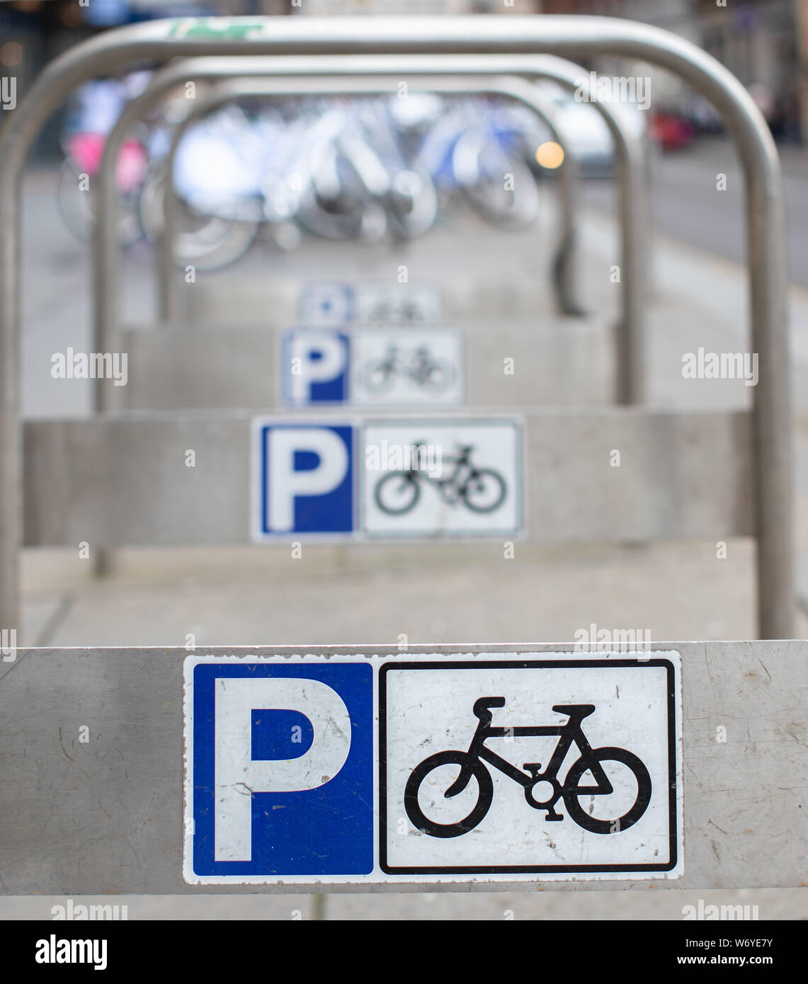 Parcheggio per bici con cartelli in un centro città molto trafficato Foto Stock