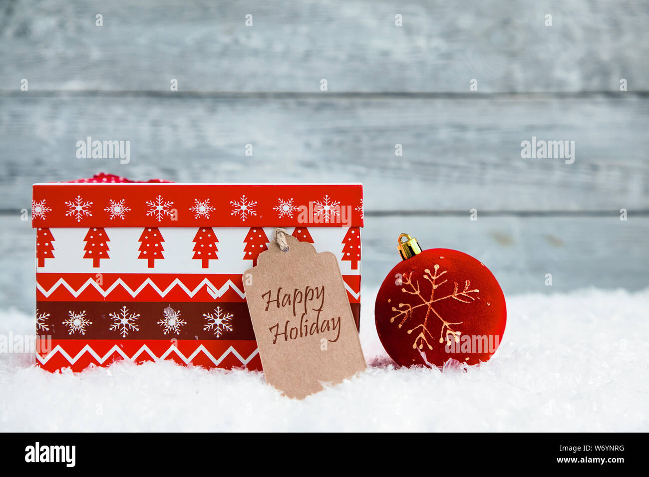 Rosso scatola di Natale sulla neve e lo sfondo di legno Foto Stock