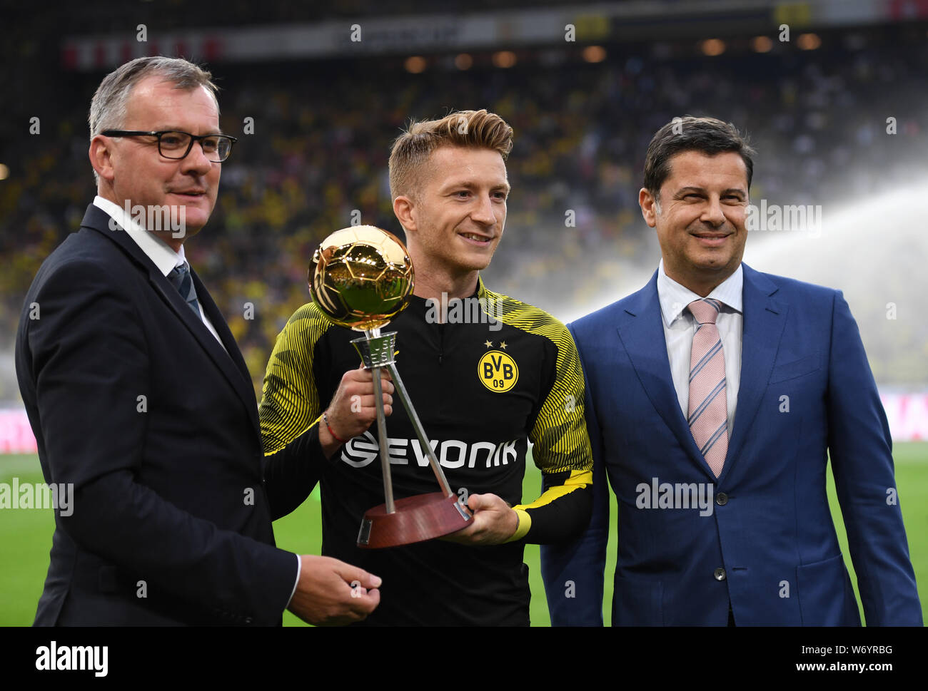 Dortmund, Germania. 03 Ago, 2019. Calcio: DFL Supercup, Borussia Dortmund - Bayern Monaco di Baviera in Signal Iduna Park. Dortmund il Marco Reus (M) riceve il trofeo come 'Calciatore dell'anno" da kicker editor-in-chief Jörg Jakob (l) e Christian Seifert, Managing Director della Lega calcio tedesca. Credito: Marius Becker/dpa/Alamy Live News Foto Stock
