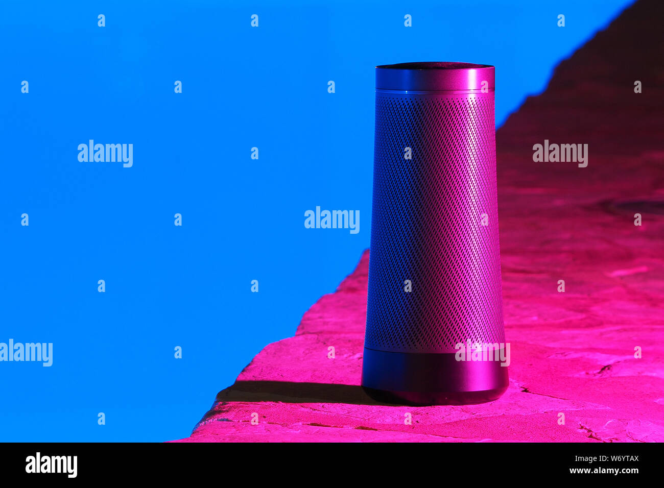 Portatile altoparlante moderno con Assistente vocale durante la notte nei pressi della piscina una luce al neon. Foto Stock