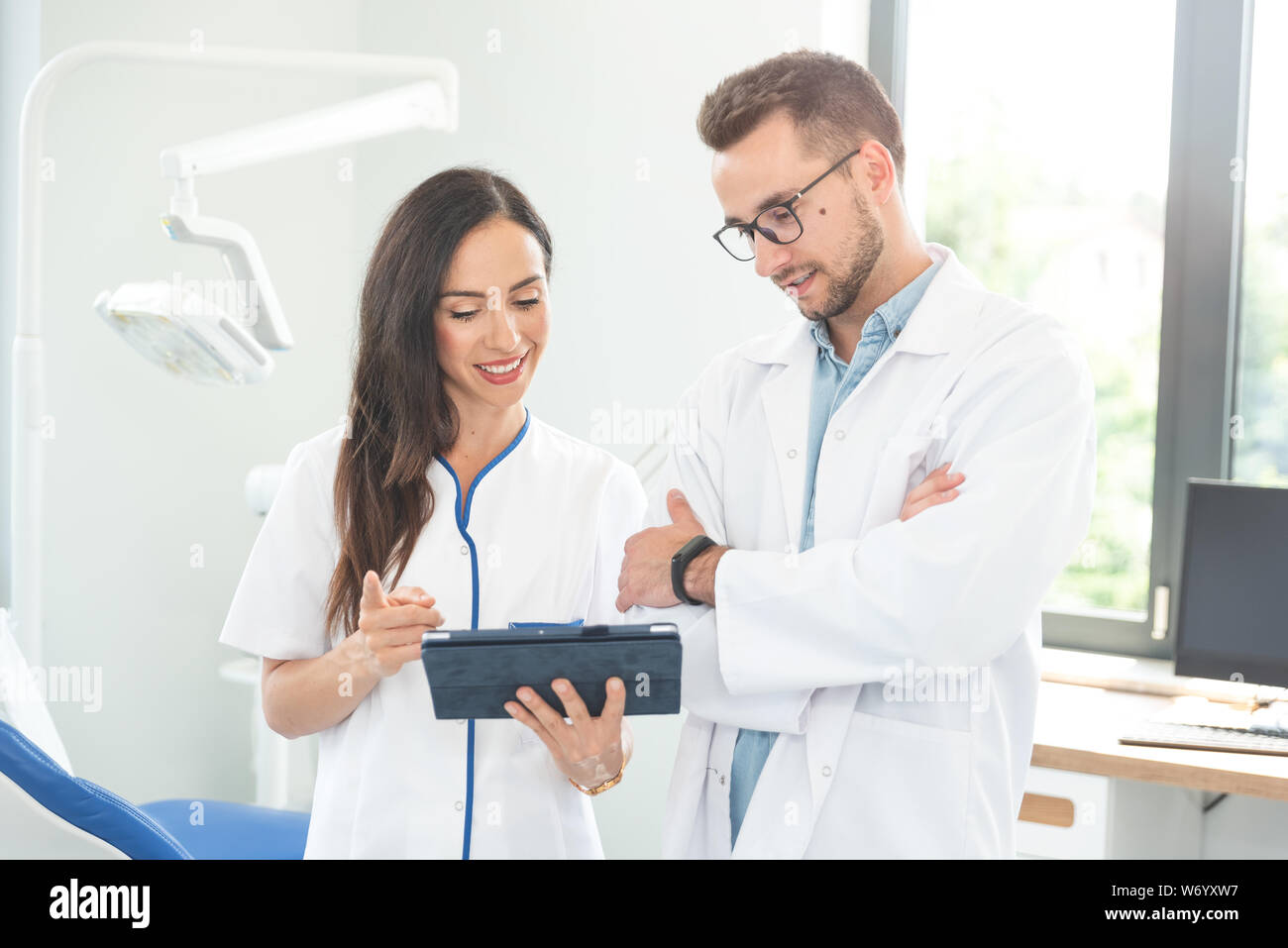 Lavoratori medici lavorano insieme in ufficio. Medico donna azienda digitale compressa. Foto Stock