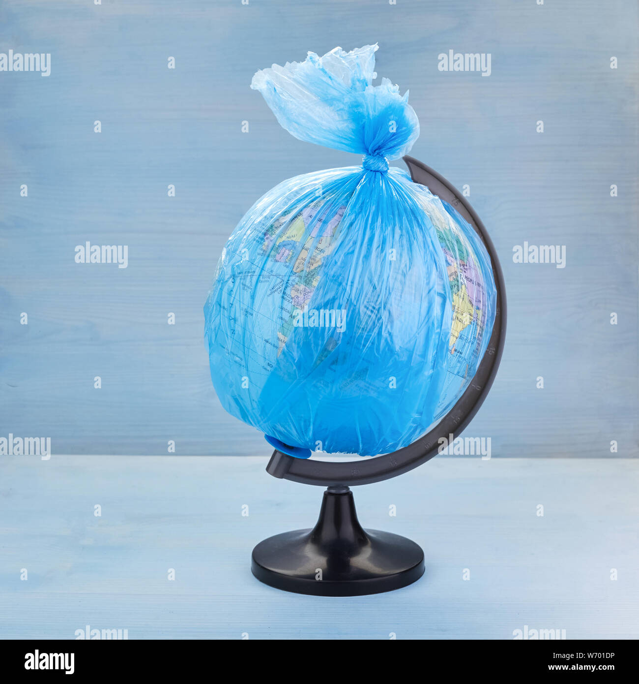 Globo del pianeta Terra vestito in un garbage sacchetto di plastica blu su  sfondo di legno Foto stock - Alamy