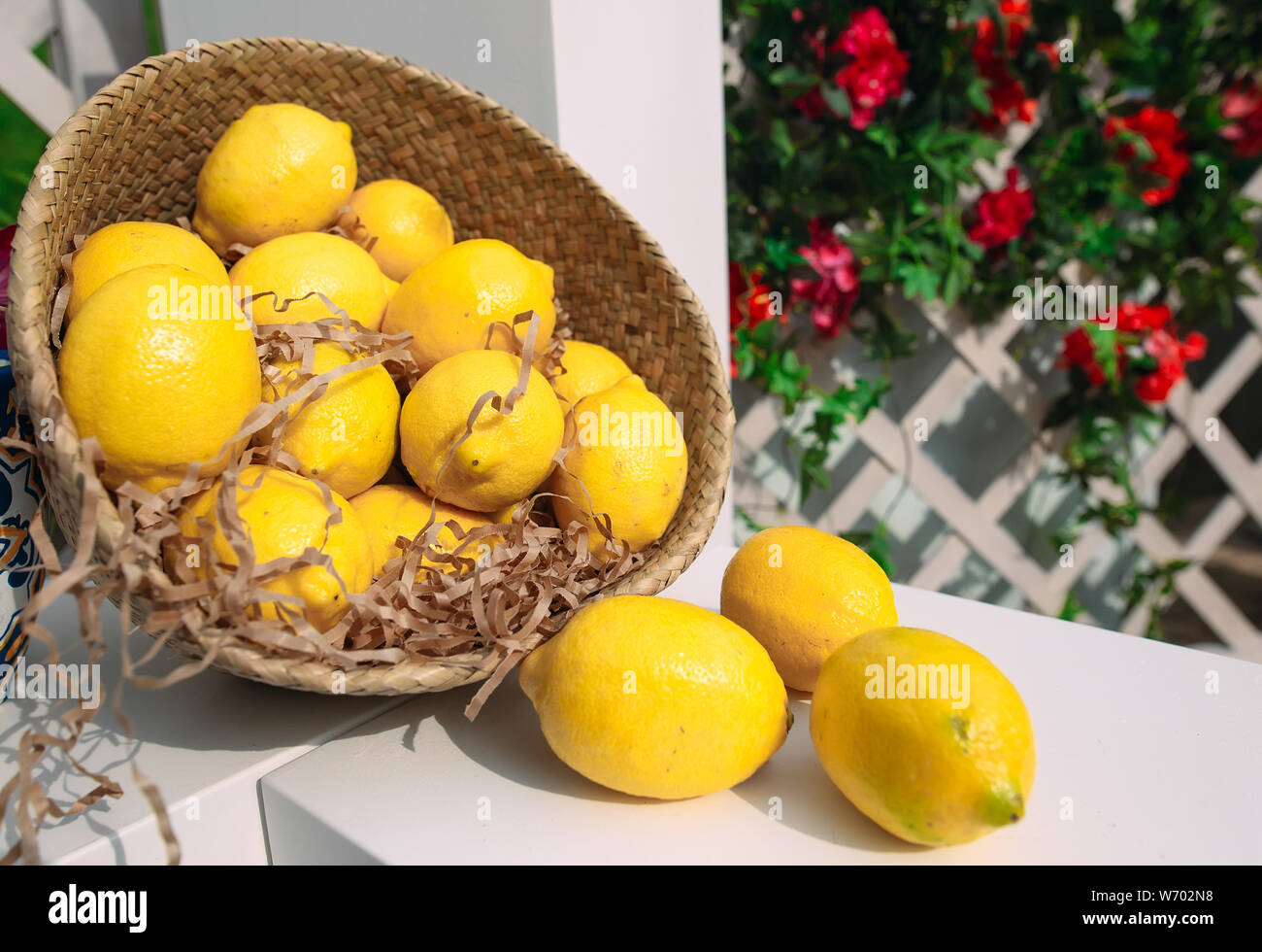 Un cesto di vimini con limoni freschi e le strisce di carta. Foto Stock