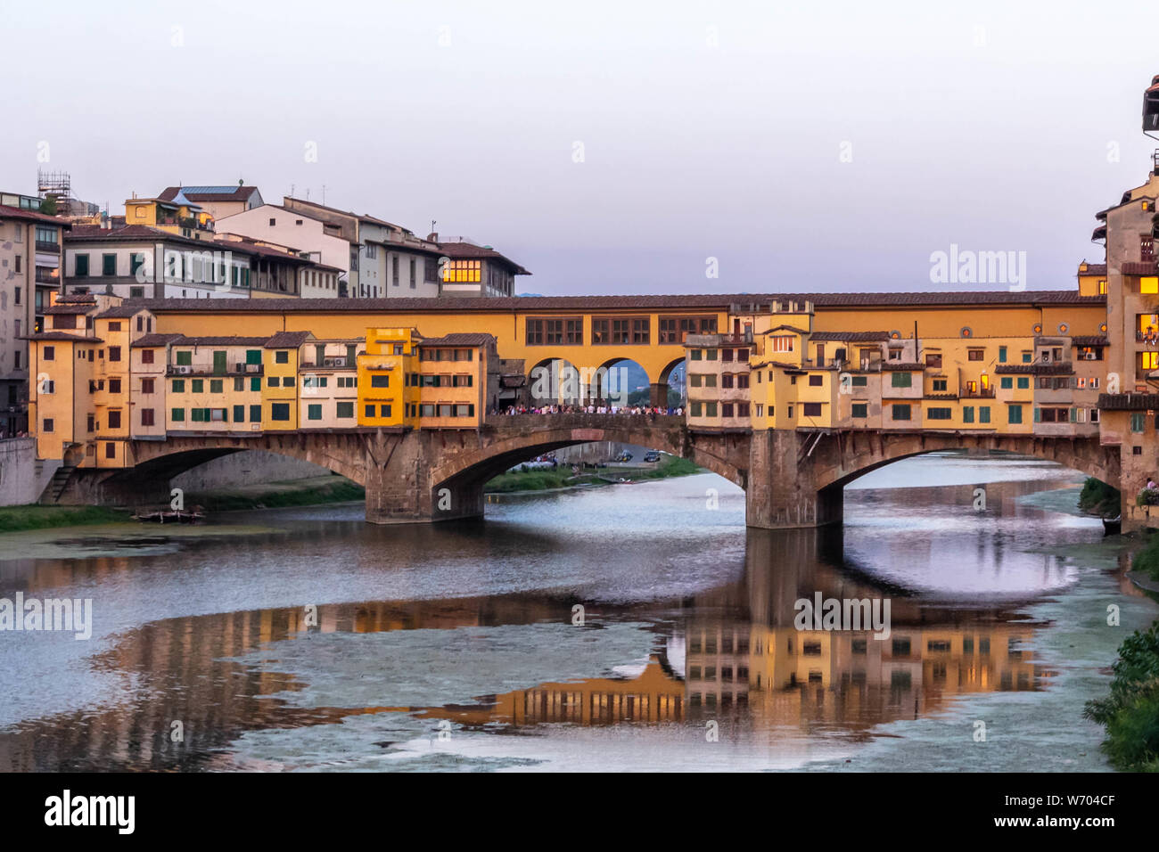 Paesaggio urbano di Firenze, il famoso Ponte Vecchio oltre il fiume Arno al tramonto a Firenze, Italia. Foto Stock