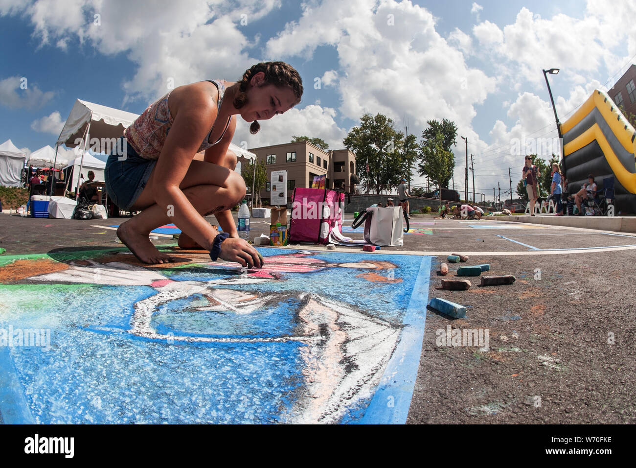 Sandy Springs, GA, Stati Uniti d'America - 22 Settembre 2018: una ragazza adolescente trae chalk arte sul pavimento in un chalk concorso artistico a Sandy Springs Festival. Foto Stock