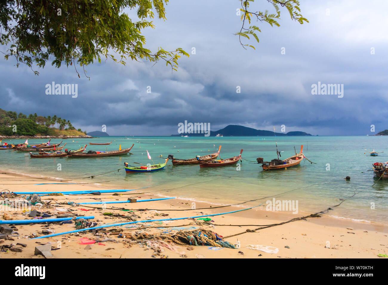 Barche da pesca ormeggiate in una baia con un avvicinamento tempesta, Rawai, Phuket, Tailandia Foto Stock