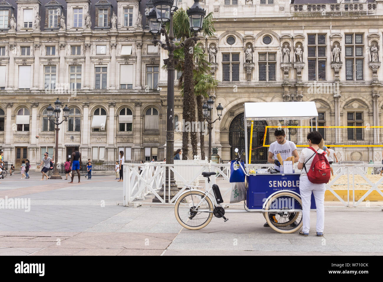 Paris street food - una turista comprare un gelato Senoble da una bicicletta carrello su una strada di Parigi. In Francia, in Europa. Foto Stock