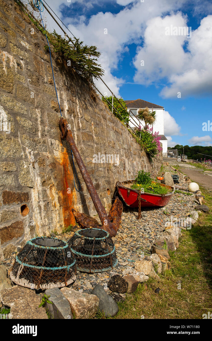Regno Unito, Inghilterra, Cornwall, Newlyn, Porto, Old Quay grande ancora di ferro, aragosta pentole e barca a remi da parete del porto Foto Stock