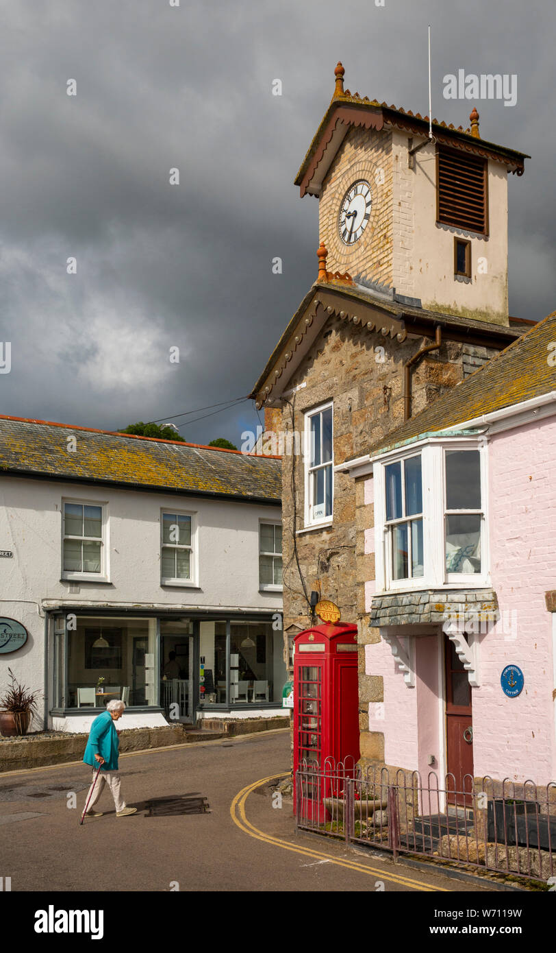 Regno Unito, Inghilterra, Cornwall, Mousehole, North Cliff, vecchio telefono rosso a scatola di giunzione con Fore Street sotto la torre dell'orologio Foto Stock